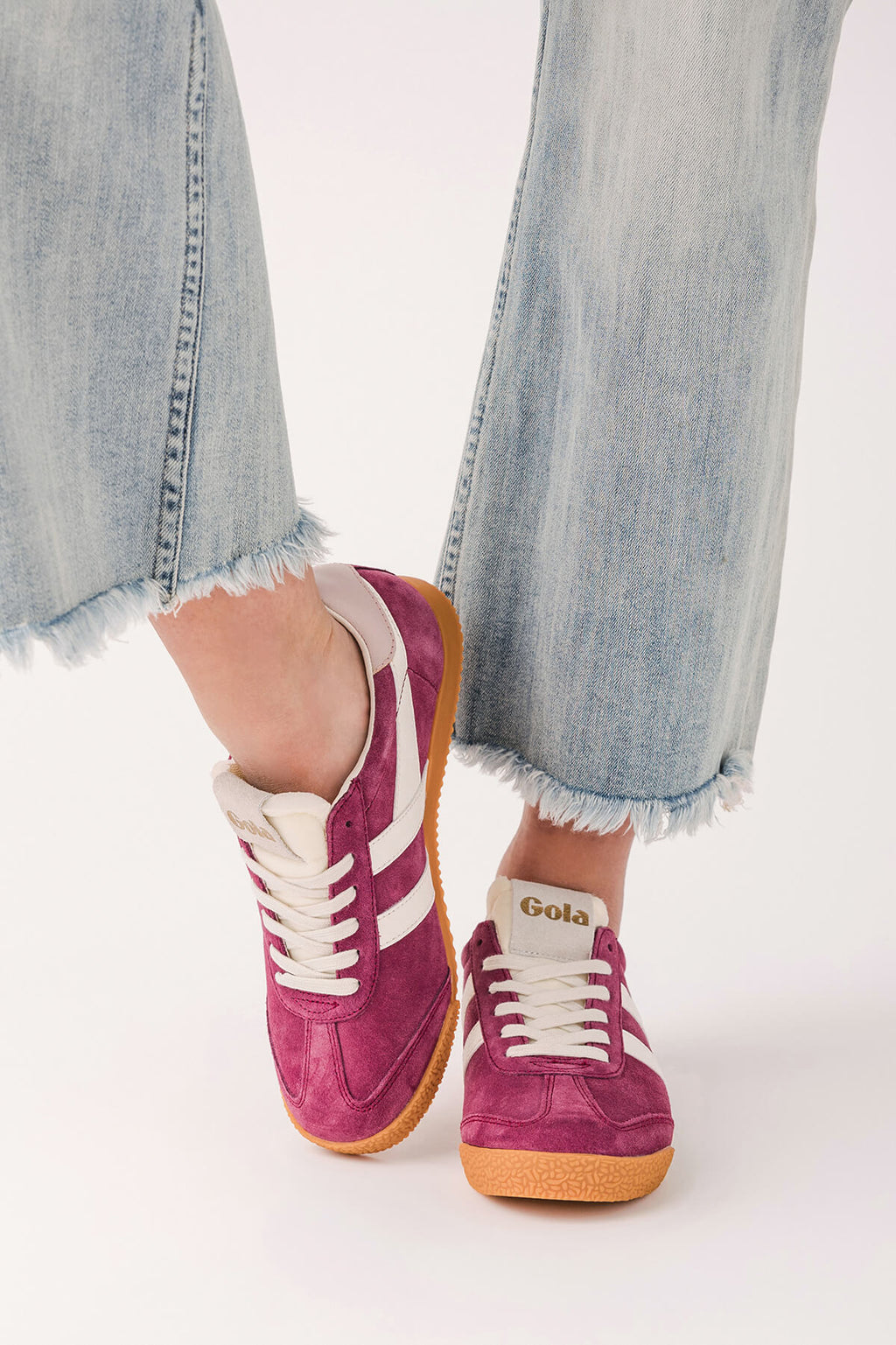 Pink suede low-top sneakers with white laces, striped side panels, gum sole.
