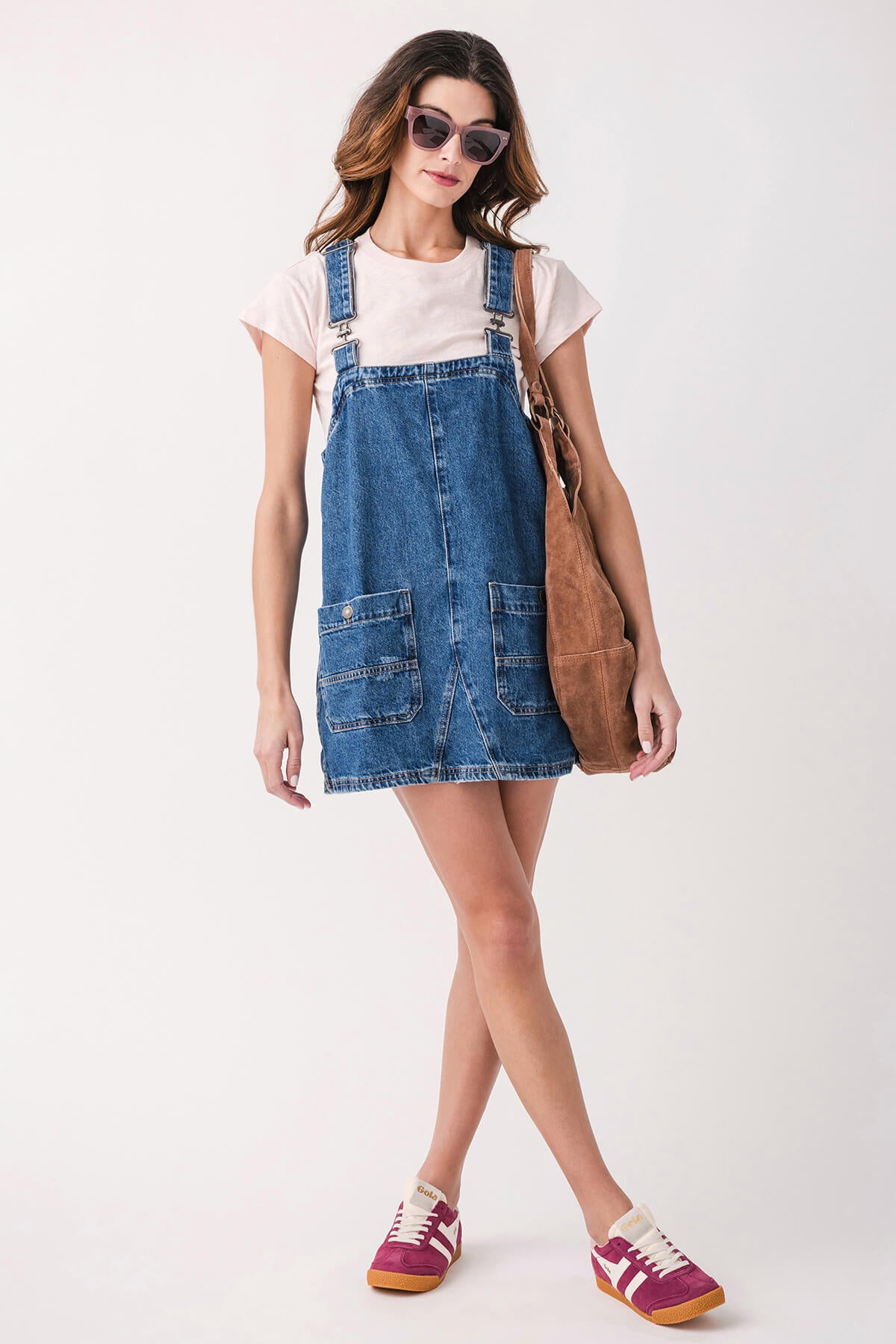 Pink and burgundy low-top sneakers with white laces and gum sole, worn with denim dress.