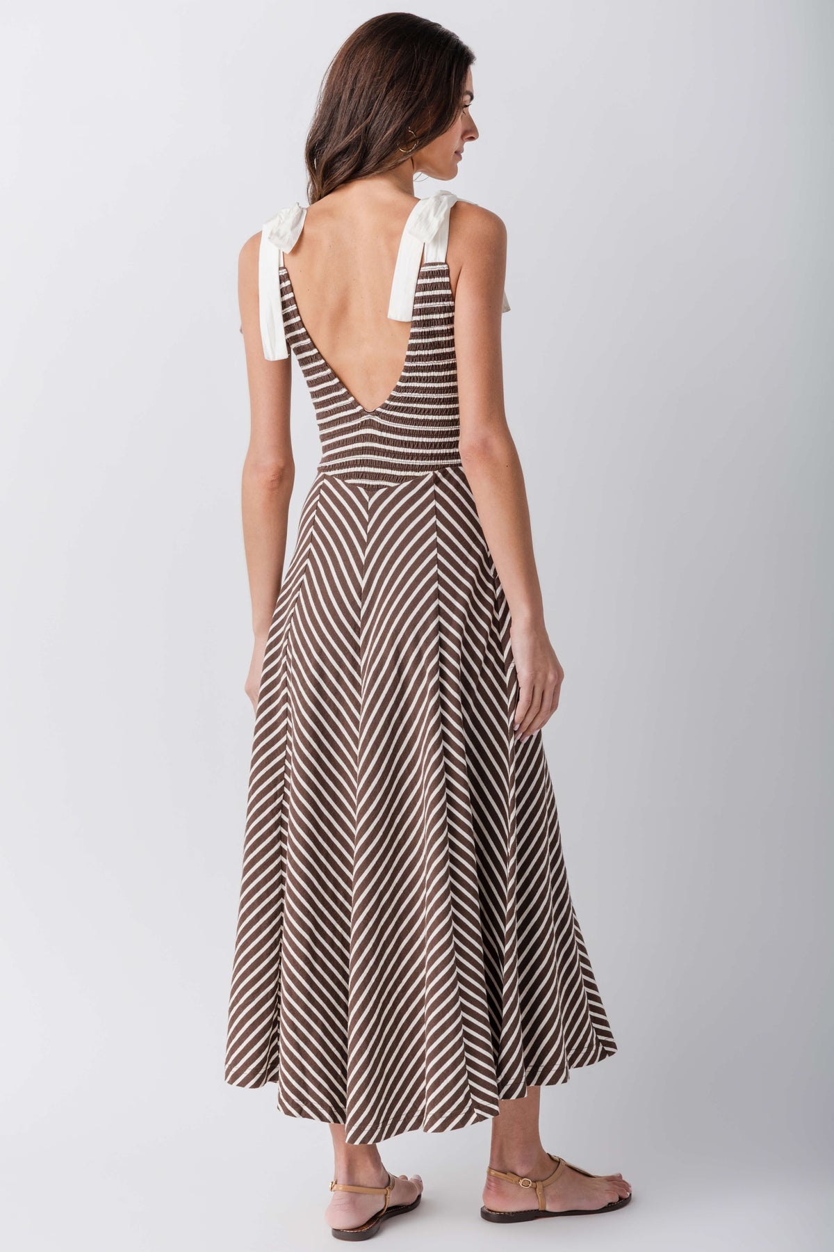 Back view of sleeveless V-neck striped midi dress with flared skirt and tie shoulders