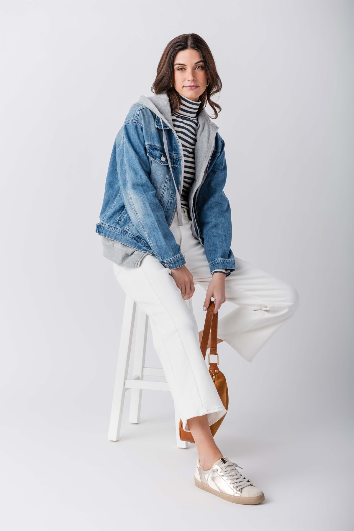 Blue denim sweatshirt jacket with gray hood and ribbed trim, seated pose view