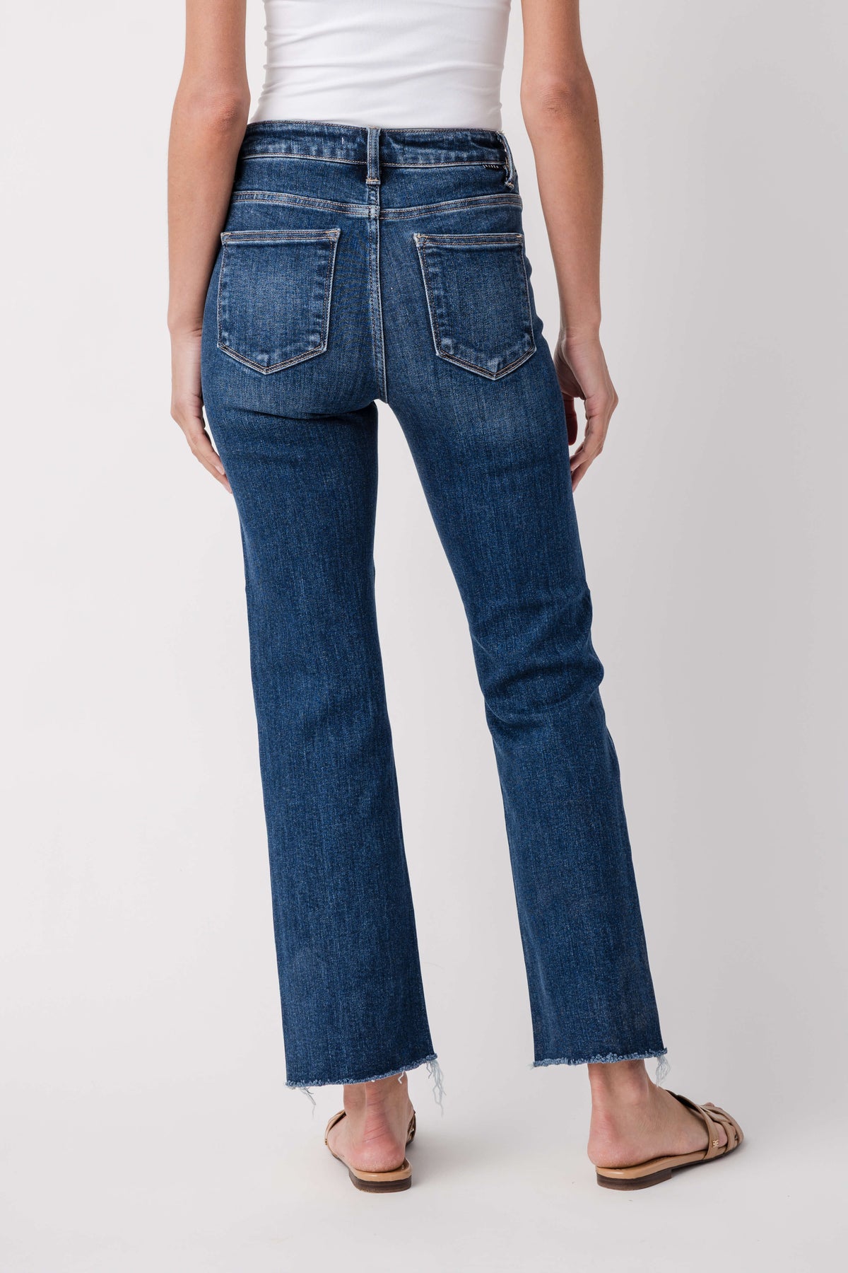 Dark blue high-rise crop straight jeans back view, double back pockets, frayed hem