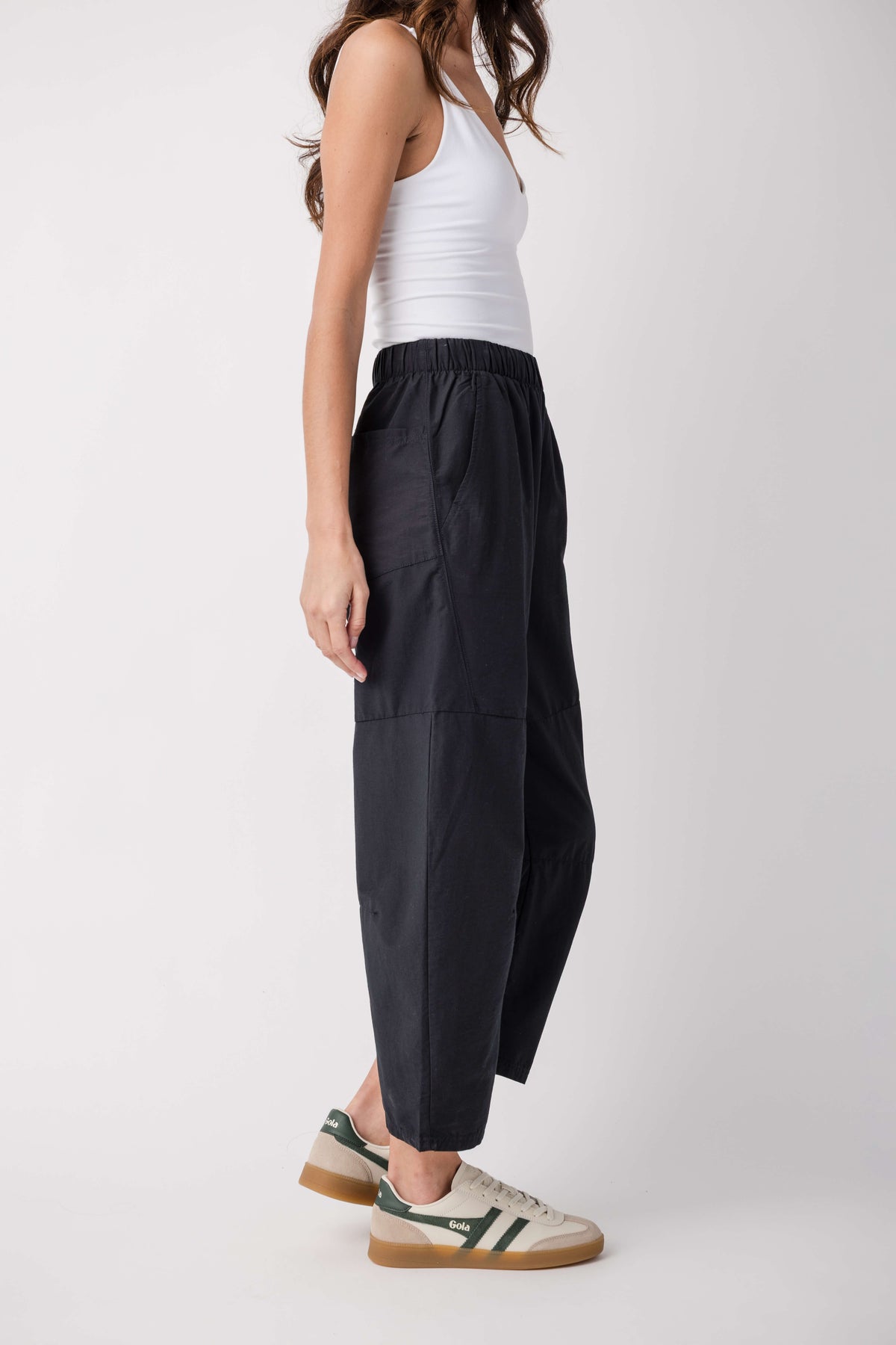 Black cropped pants with elastic waist, panel seams, and side pockets.