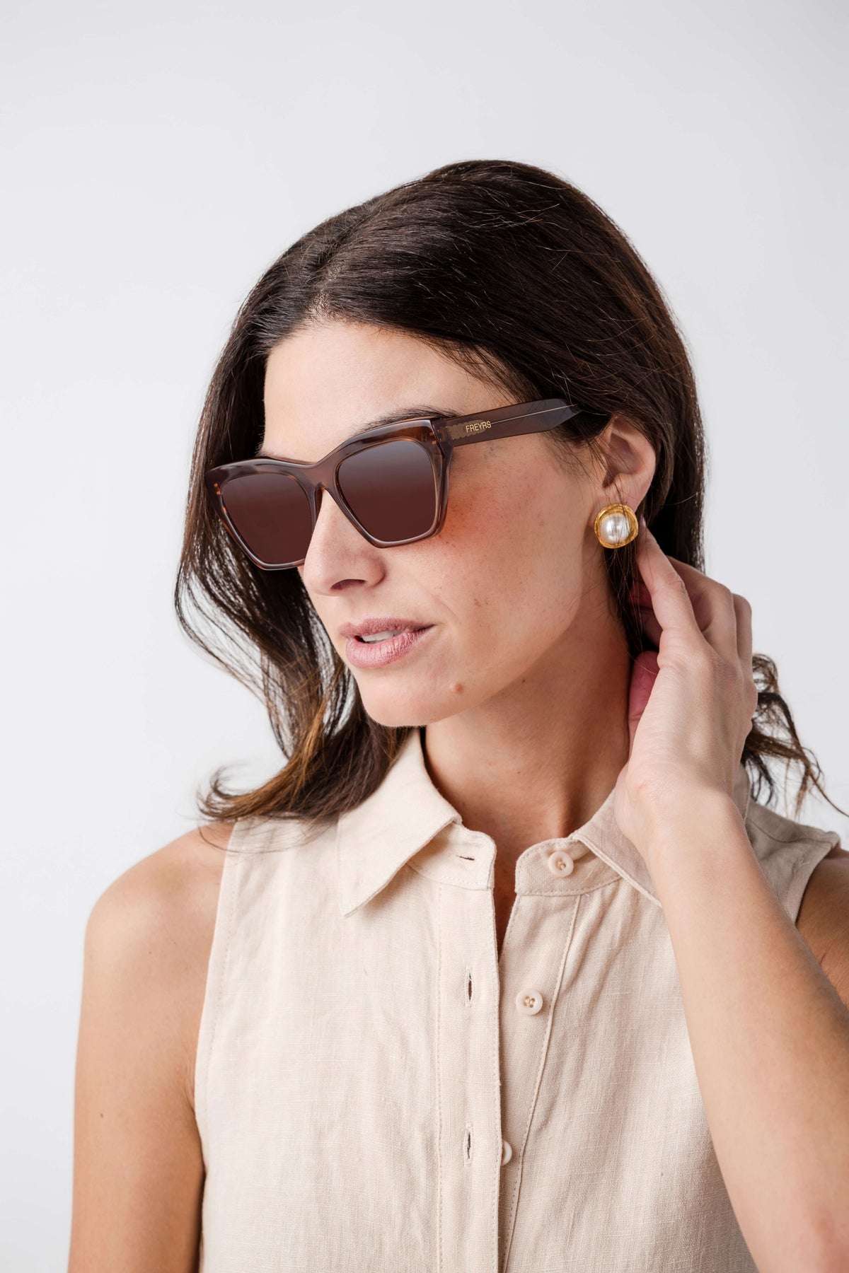Brown cat-eye sunglasses with curved temples and amber tinted lenses