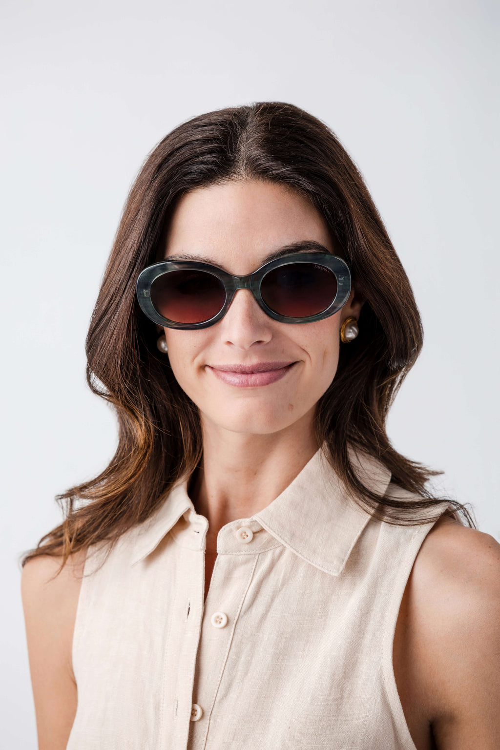 Freyrs Aria black oval sunglasses with dark lenses, worn by model facing camera