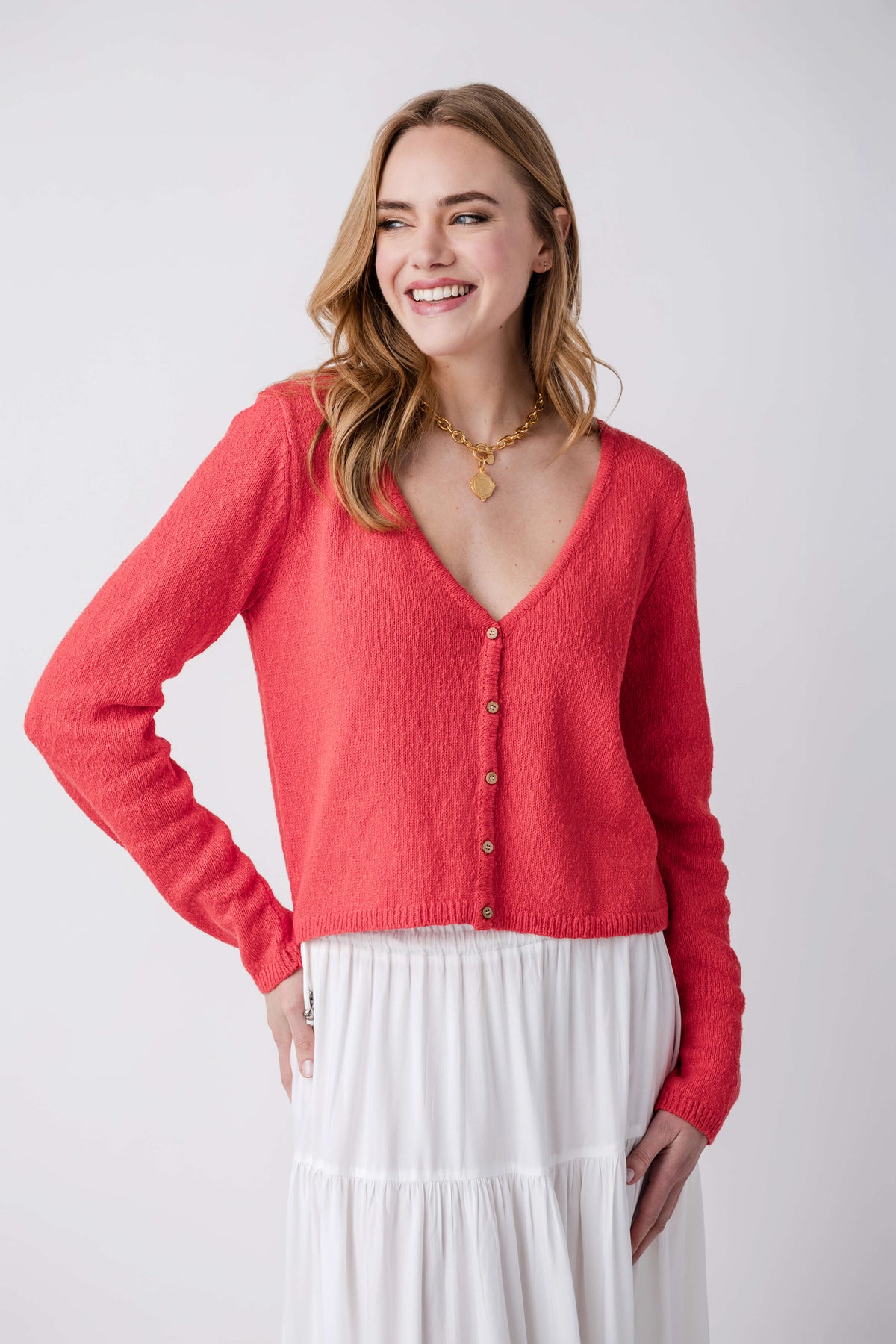 Tomato red V-neck cardigan in side view with button front and long sleeves