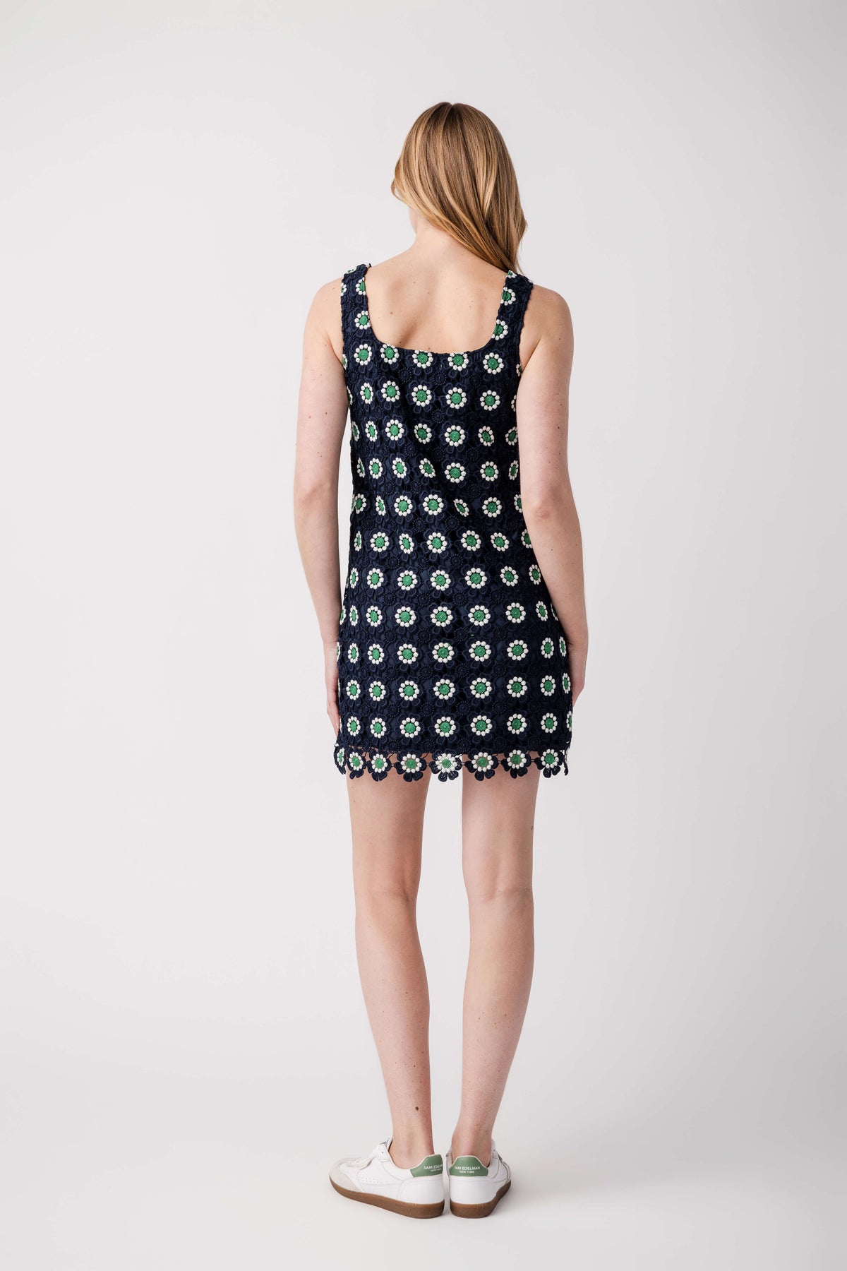 Navy sleeveless mini dress with green dot pattern and crochet lace trim, back view