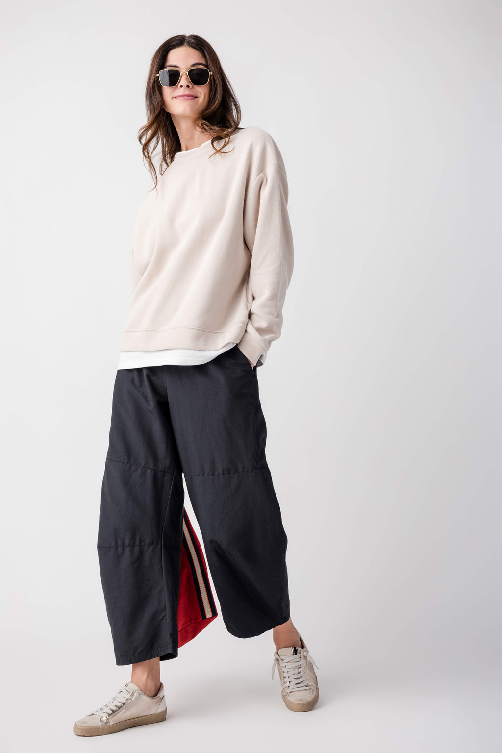 Black cropped pants with elastic waist and side stripe detail at the leg seam.