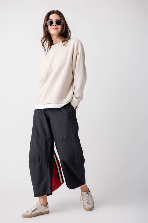 Black cropped pants with elastic waist and side stripe detail at the leg seam.