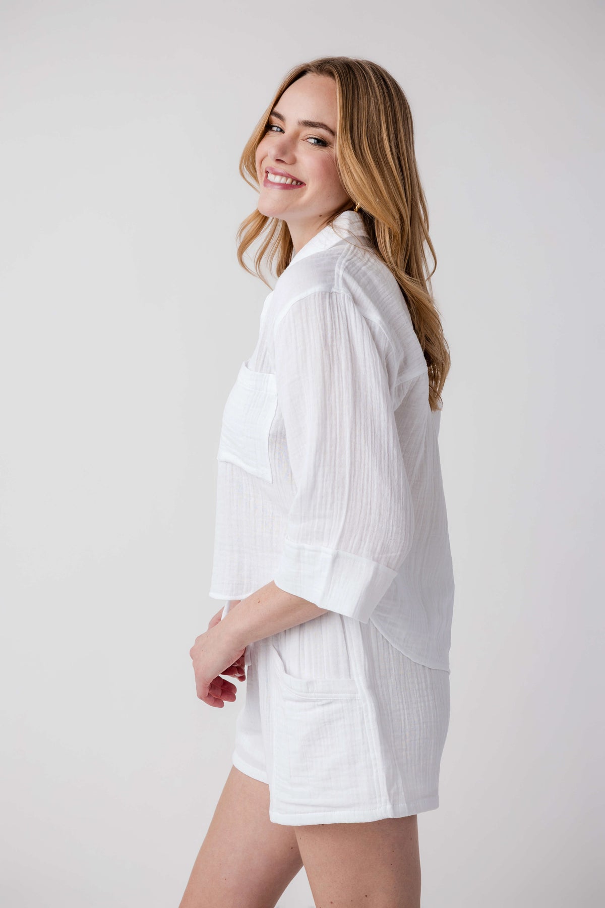 White button-front shirt with chest pockets and rolled sleeves, side view