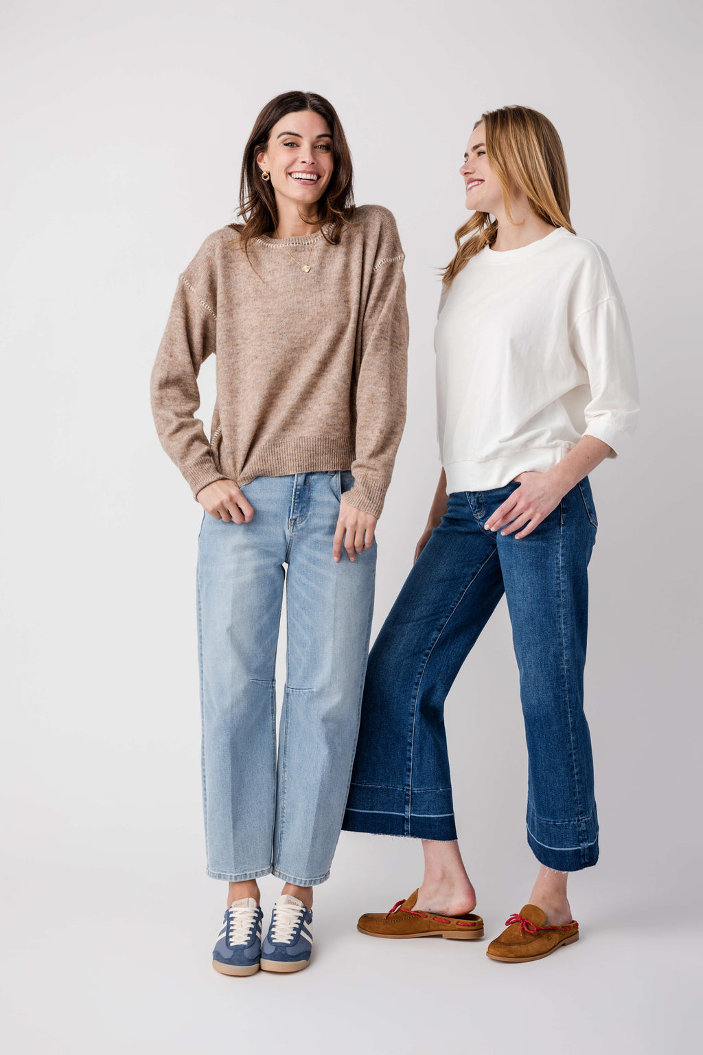 Women’s medium wash barrel jeans with relaxed fit, ankle length, worn with sneakers.