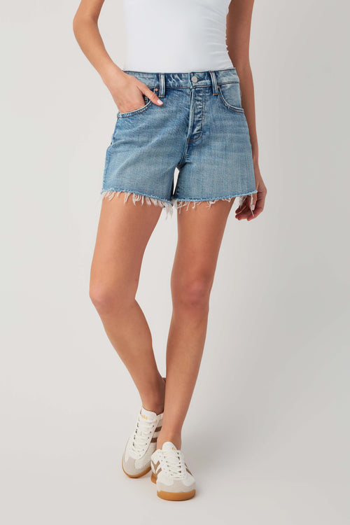 High-rise medium-wash denim shorts with raw frayed hem, back yoke and pockets