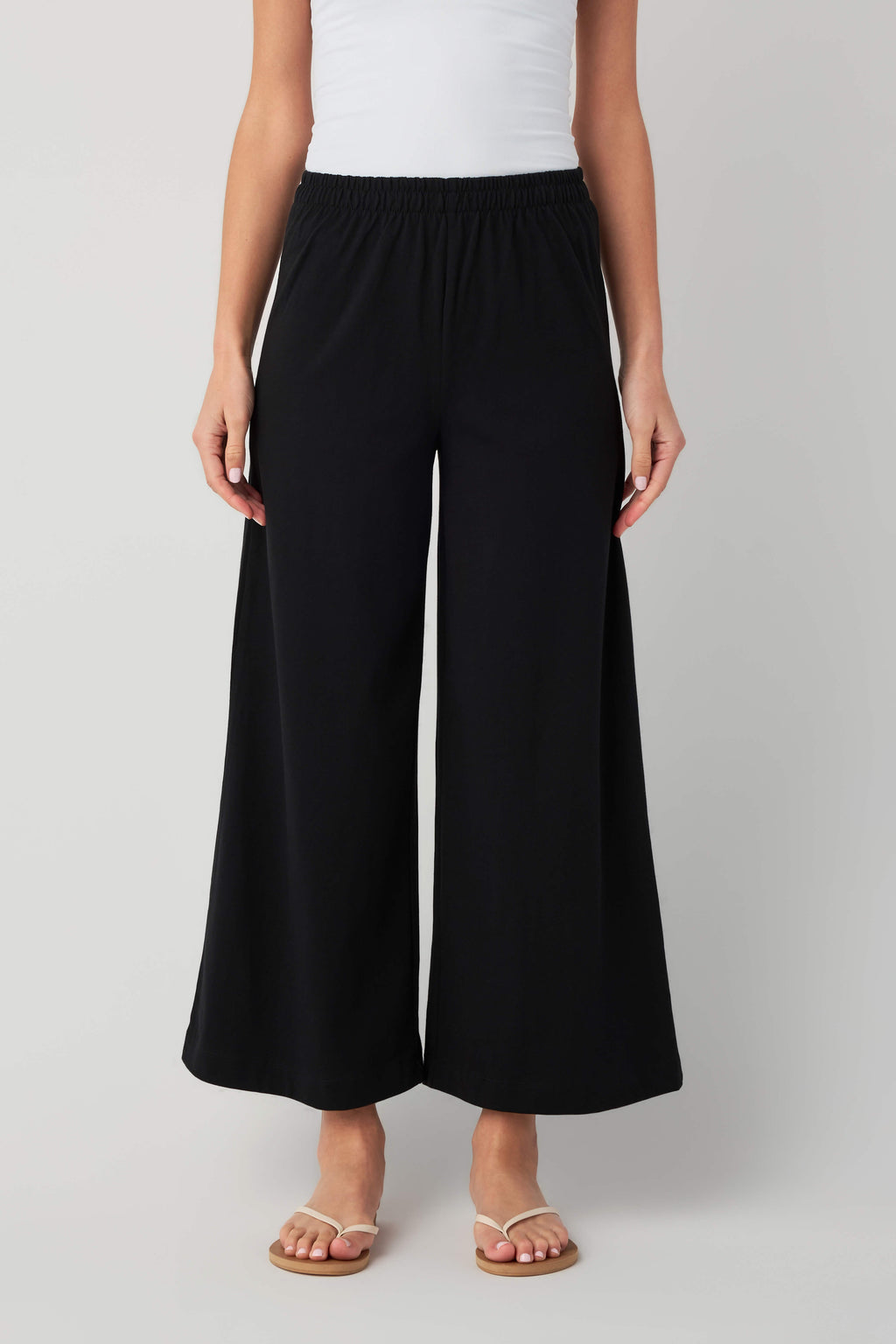 Black jersey crop flare pants with elastic waistband and wide leg