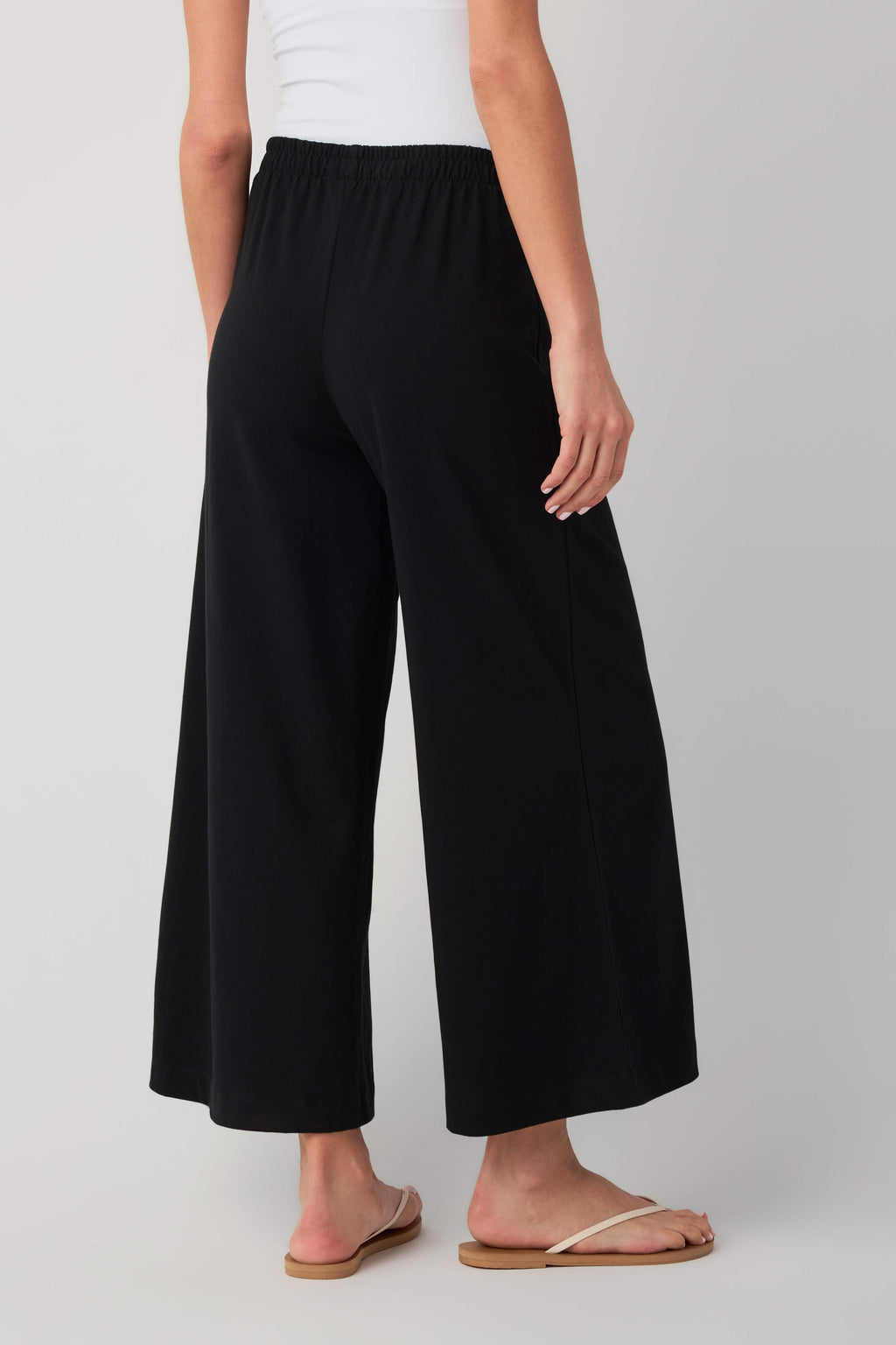Jersey crop flare pants in true black, elastic waist, wide flared legs view.