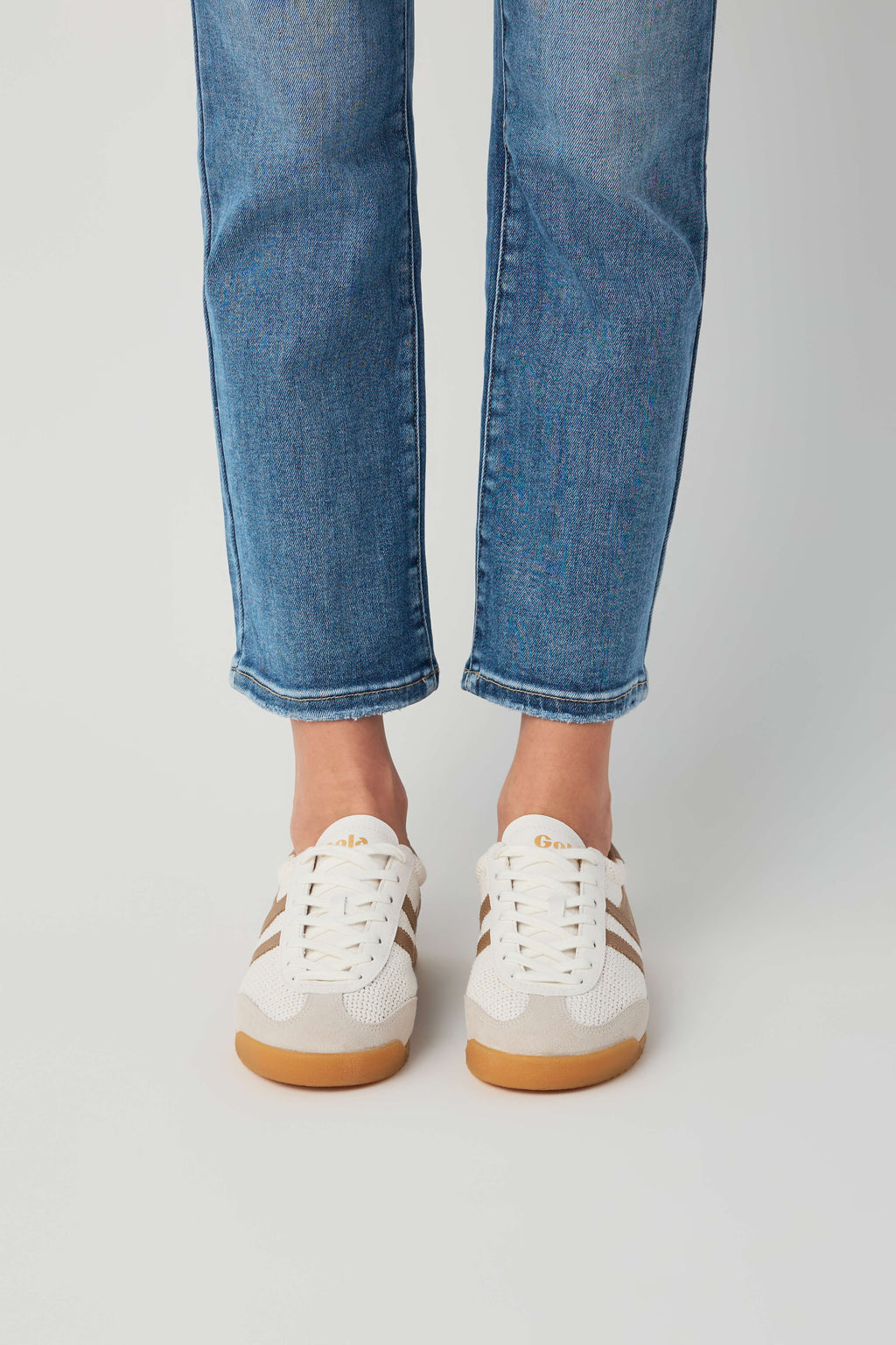 Off-white and tan low-top sneakers with lace-up front and gum rubber sole
