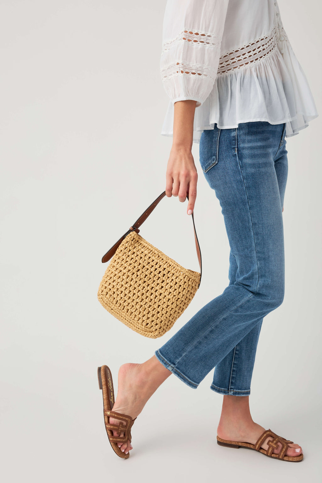 Natural woven shoulder bag with brown leather straps and short top handle