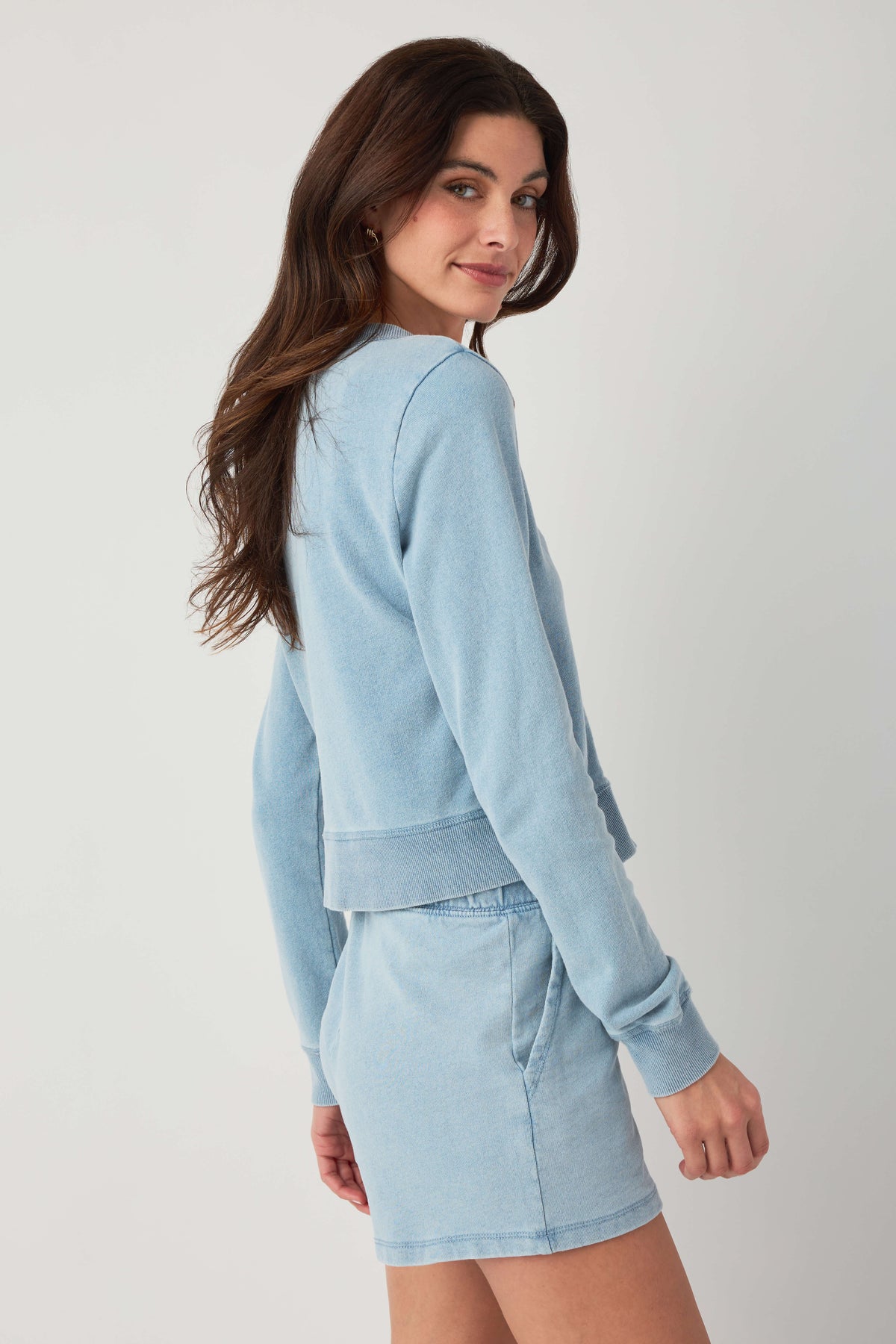Light blue denim knit cardigan angled side view with button front