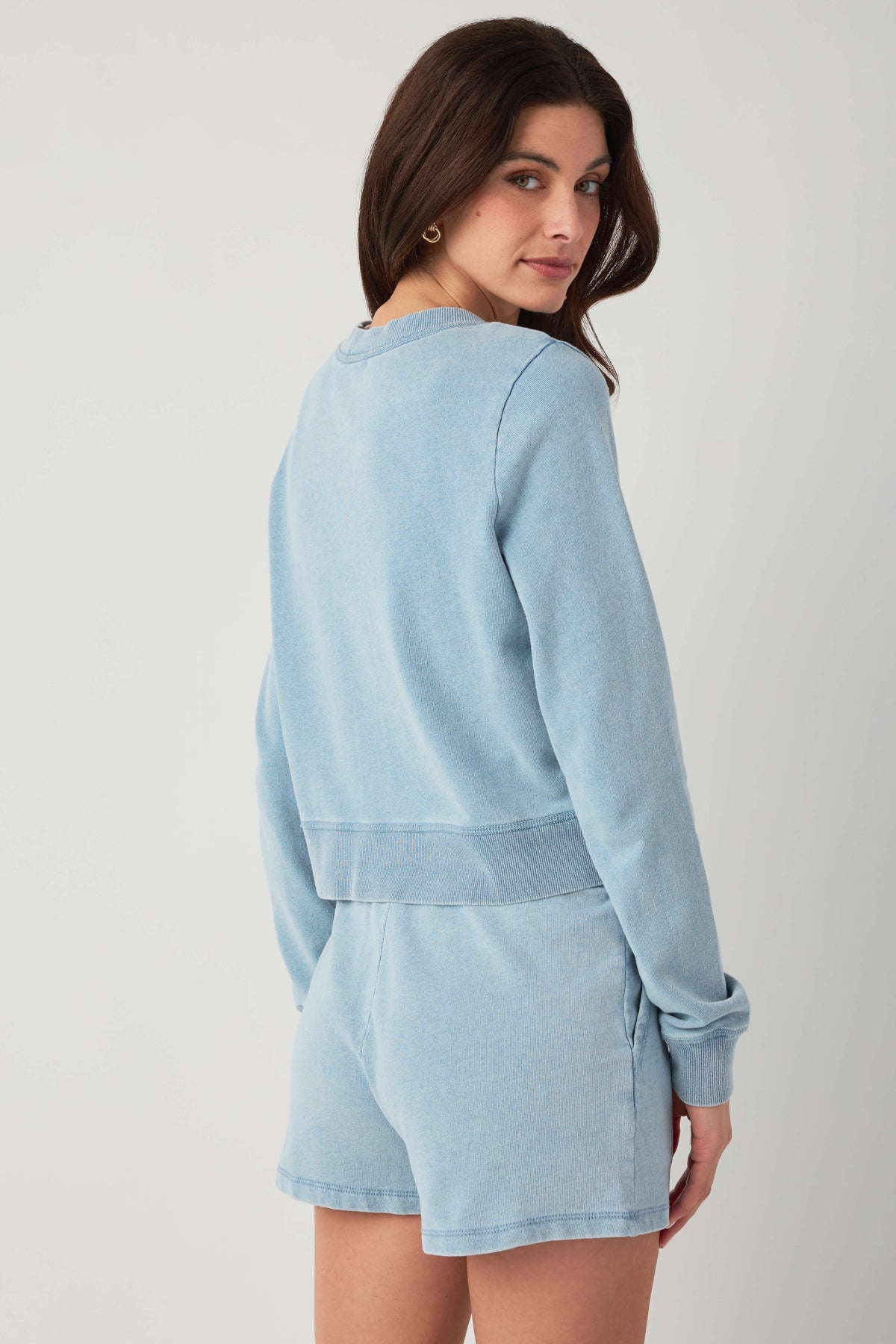 Light blue denim knit cardigan rear side view with ribbed sleeve cuffs