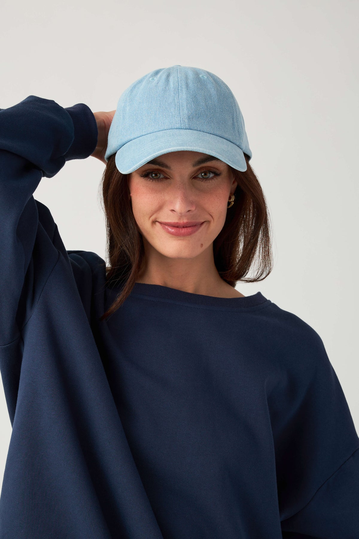 Light blue baseball cap with curved brim, worn with front-facing smile
