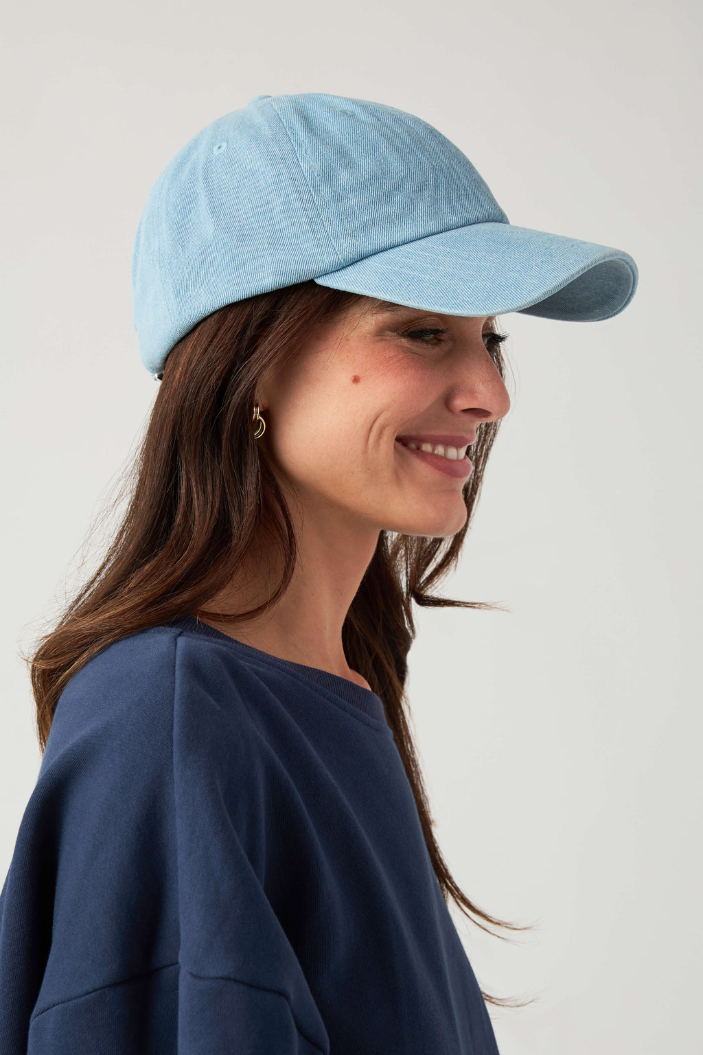 Light blue baseball cap on model side profile, curved brim and strapback