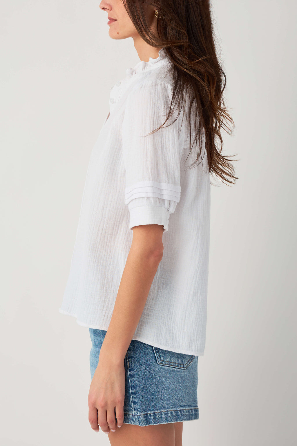 White gauze short-sleeve button blouse with ruffle collar and gathered yoke.