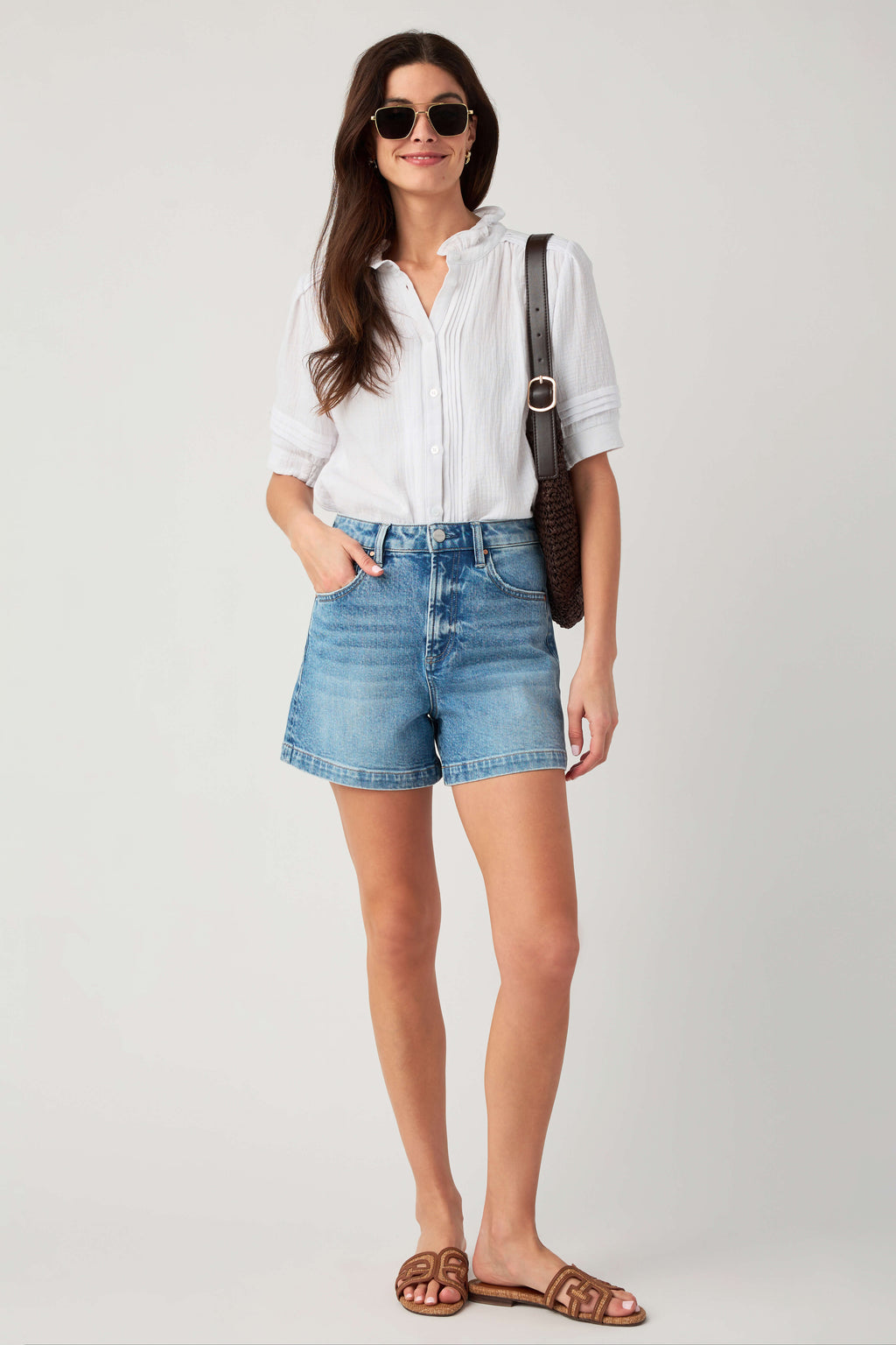 White gauze short-sleeve button blouse with ruffle collar, model standing full length.