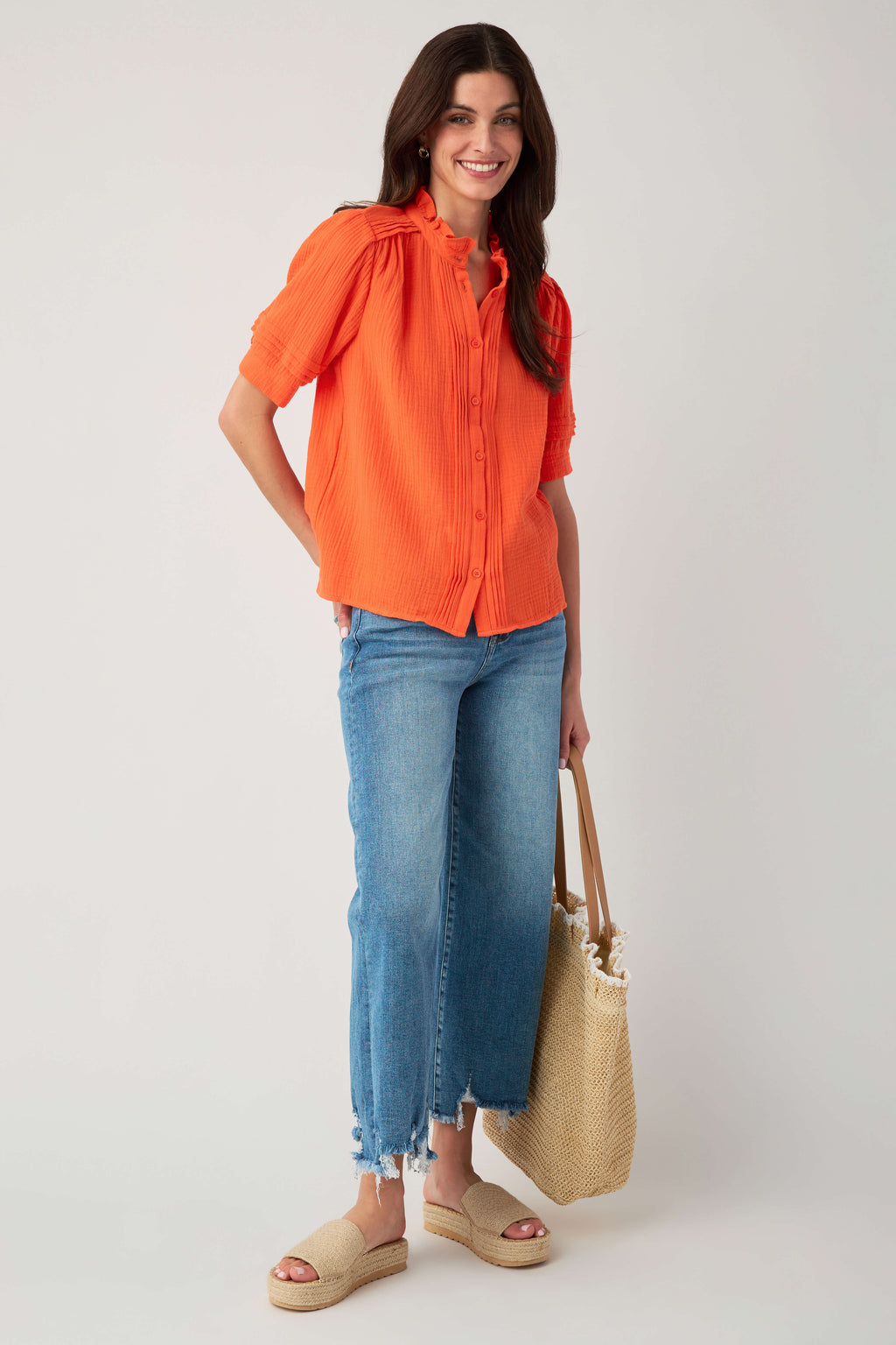 Coral gauze short-sleeve button blouse with ruffle collar and vertical textured detail.