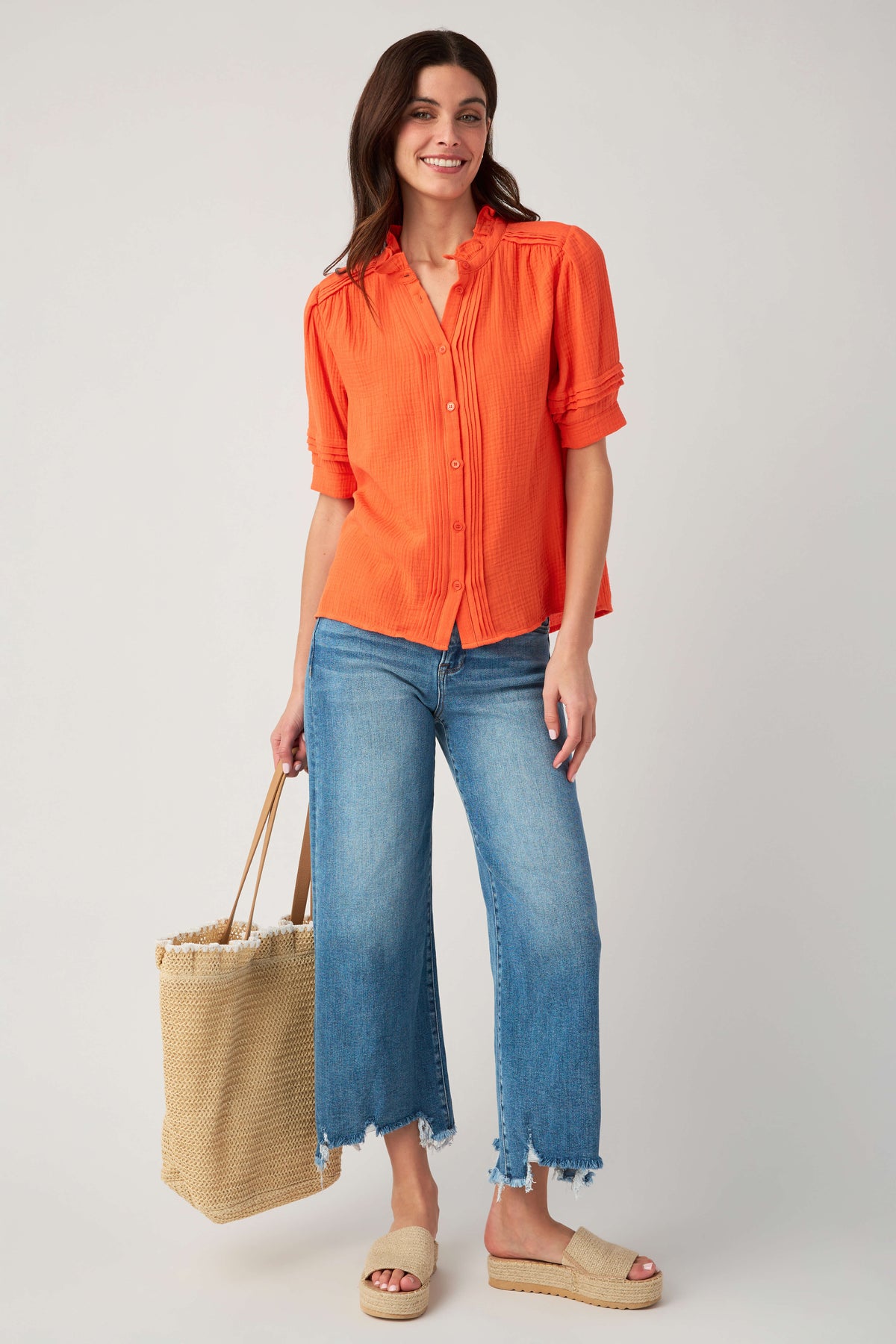 Coral gauze short-sleeve button blouse with ruffle collar and button-up front.