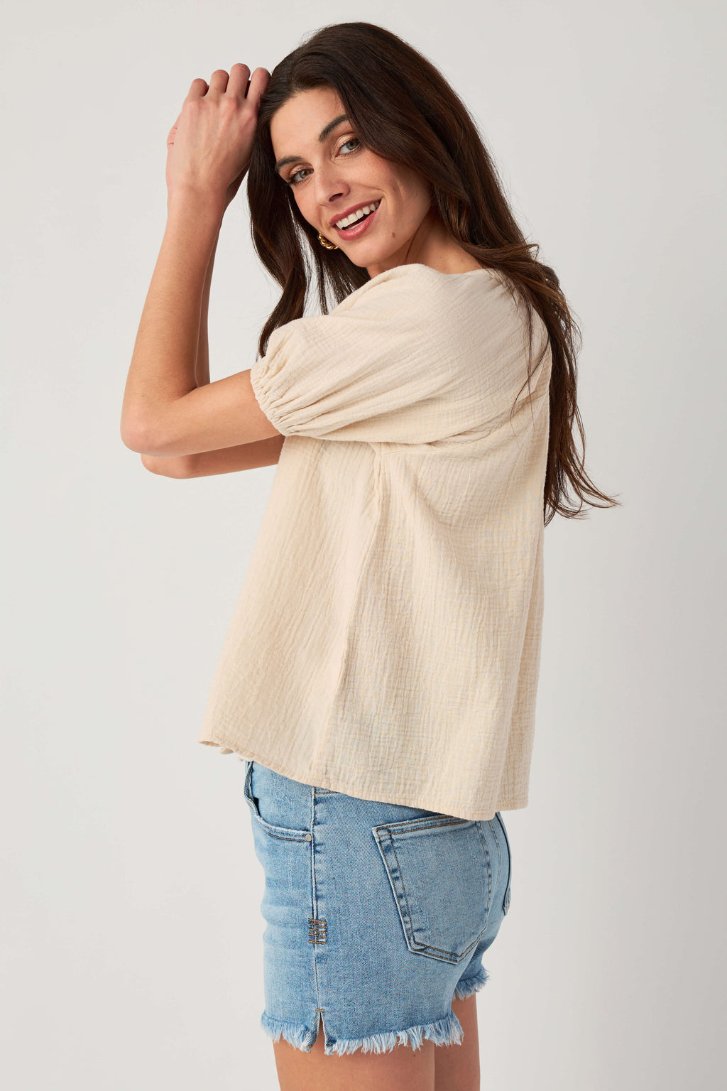 Natural gauze button-up top, side view with puff sleeves and button front