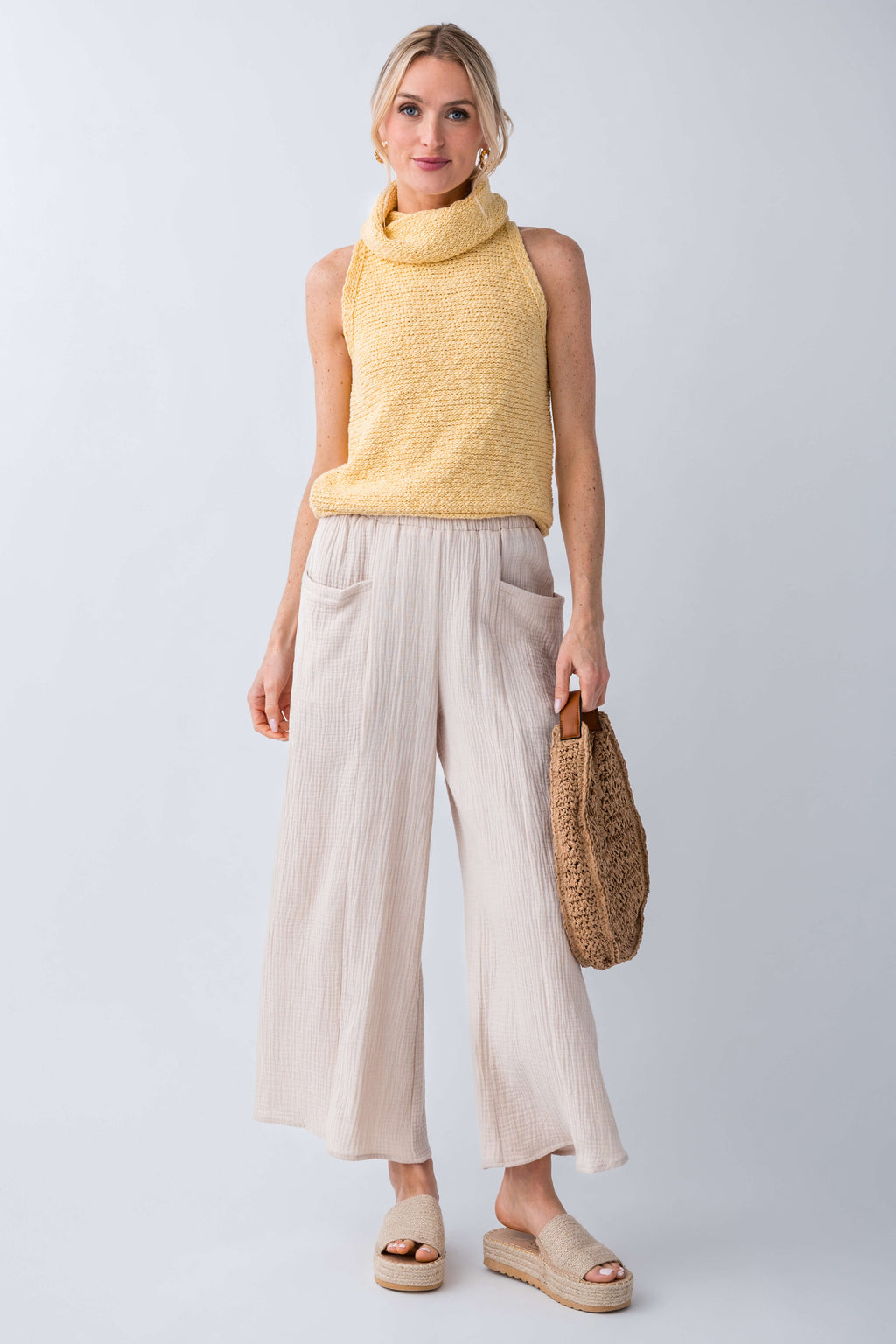 Yellow sleeveless knit turtleneck top with textured fabric and high neck