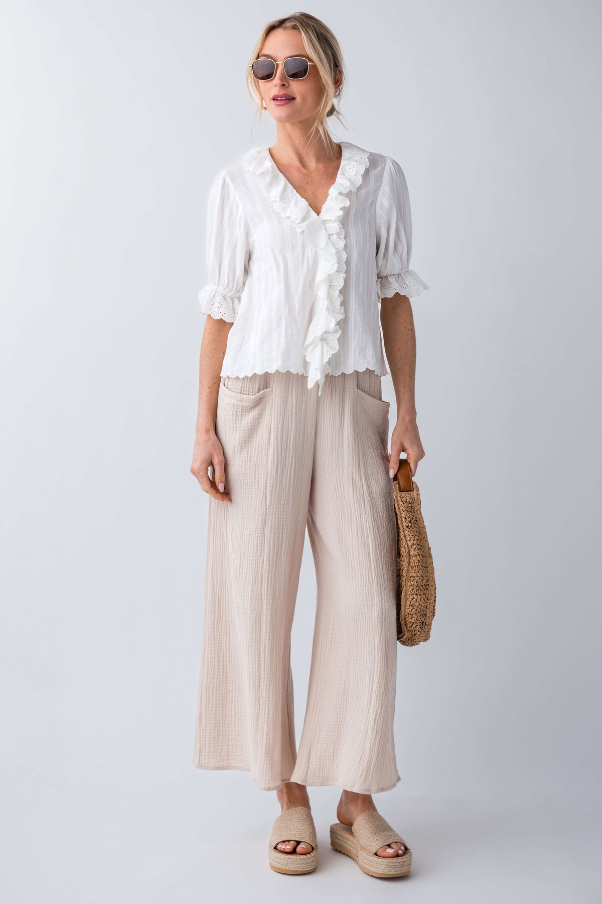 Natural raffia platform slides on model feet, open toe with woven texture