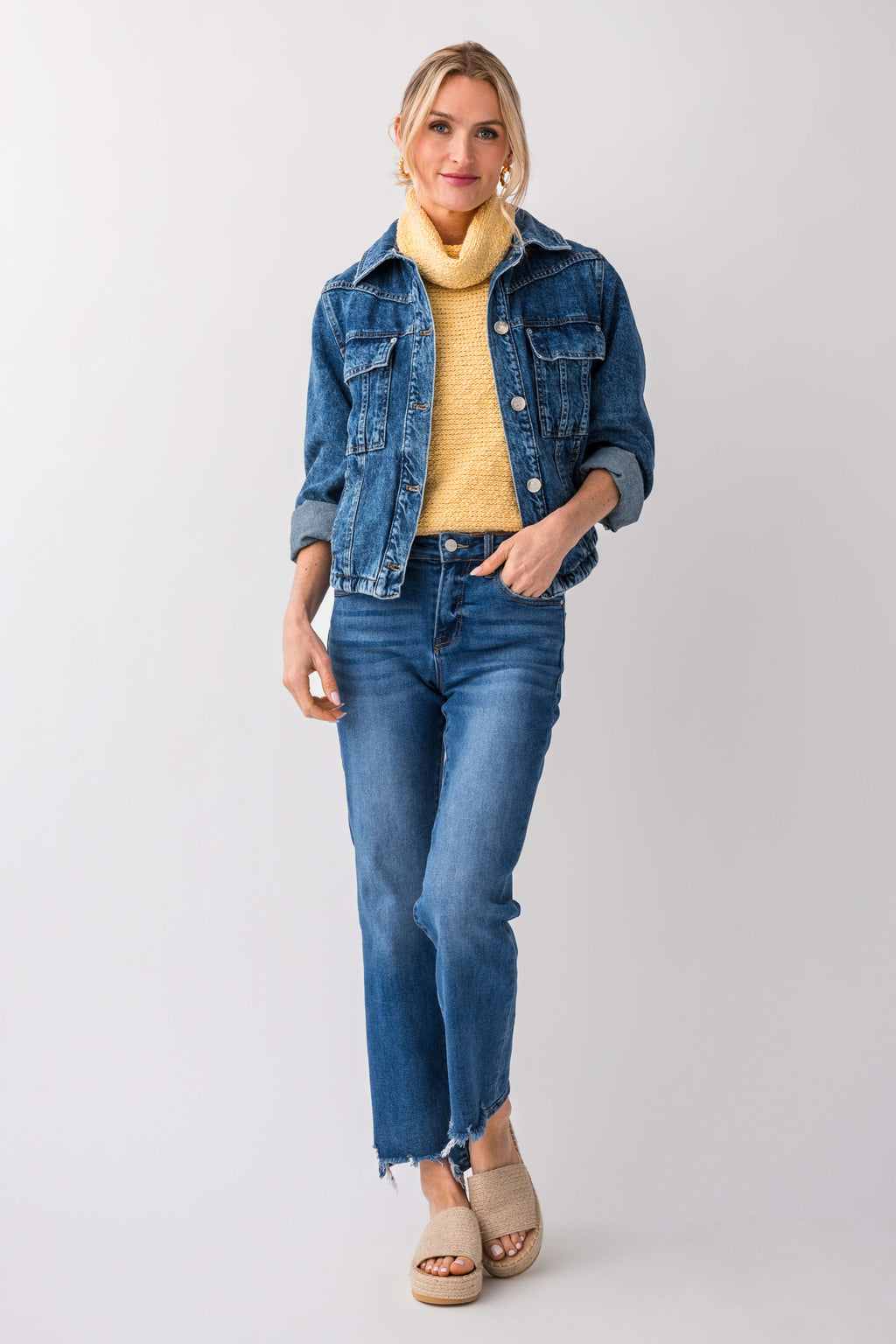 Yellow sleeveless knit turtleneck top peeking under a denim jacket