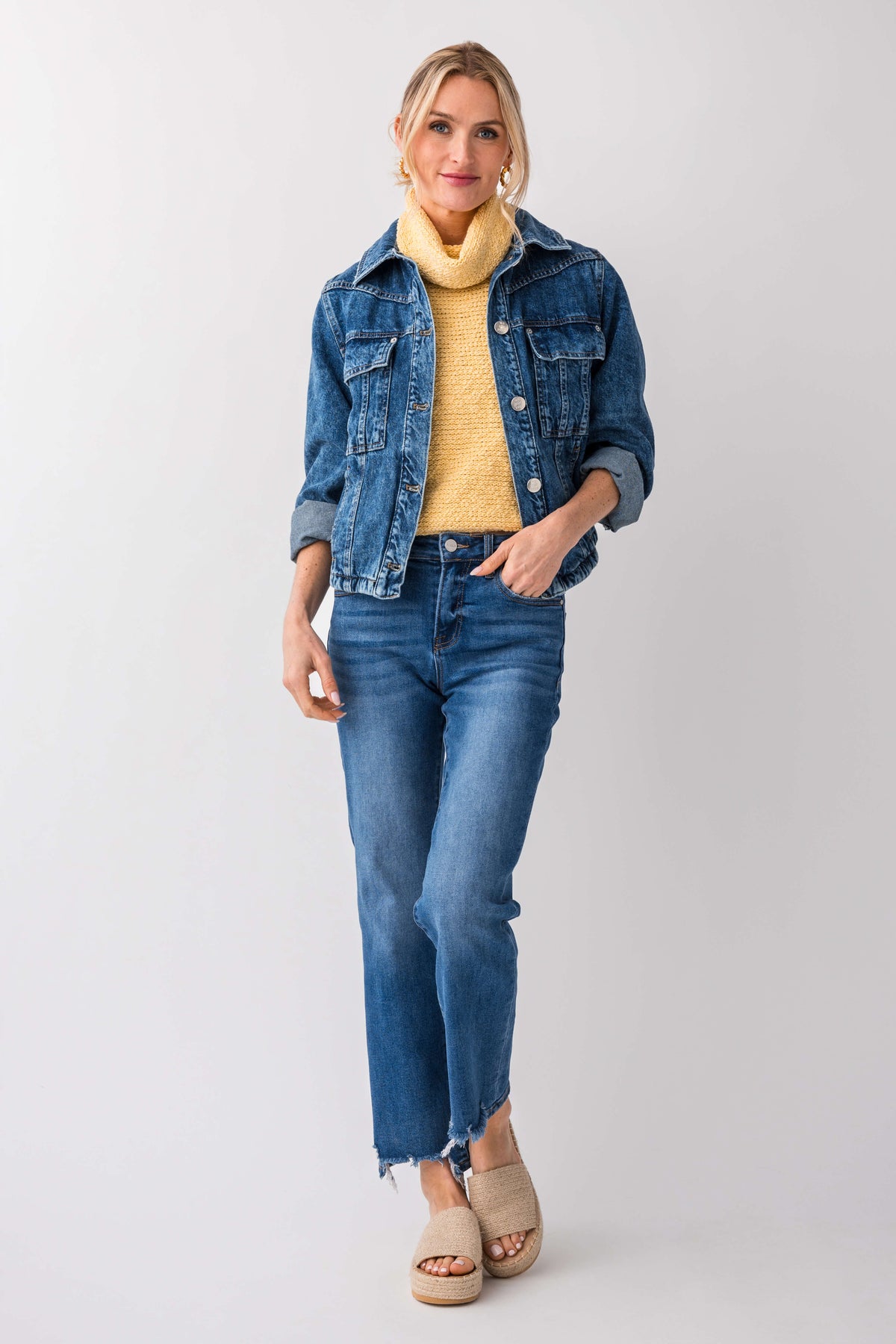 Yellow sleeveless knit turtleneck top peeking under a denim jacket