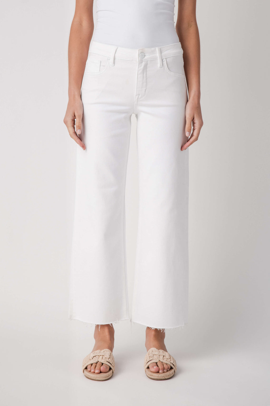 White mid-rise straight jeans with raw ankle hem and front pockets