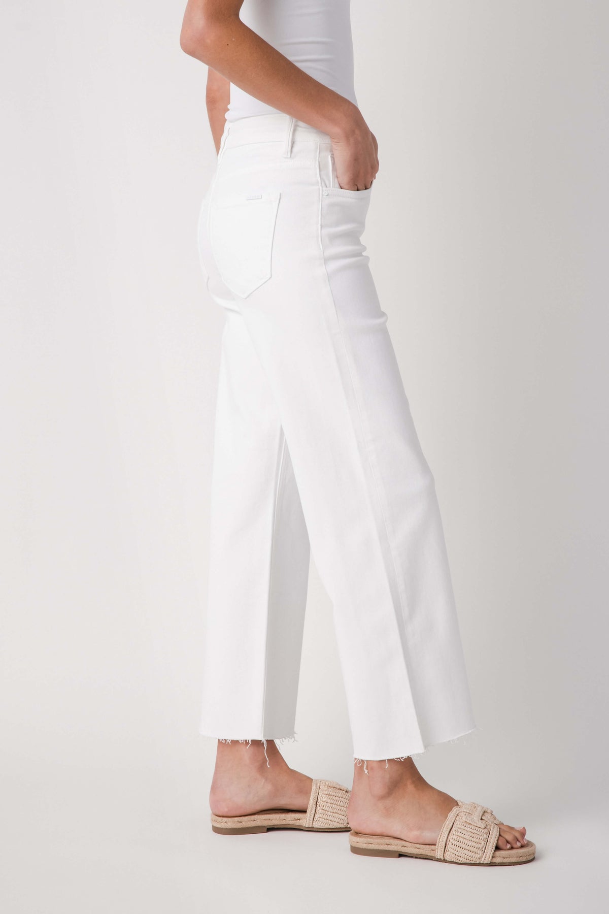 White mid-rise straight jeans, side view, raw ankle hem and belt loops