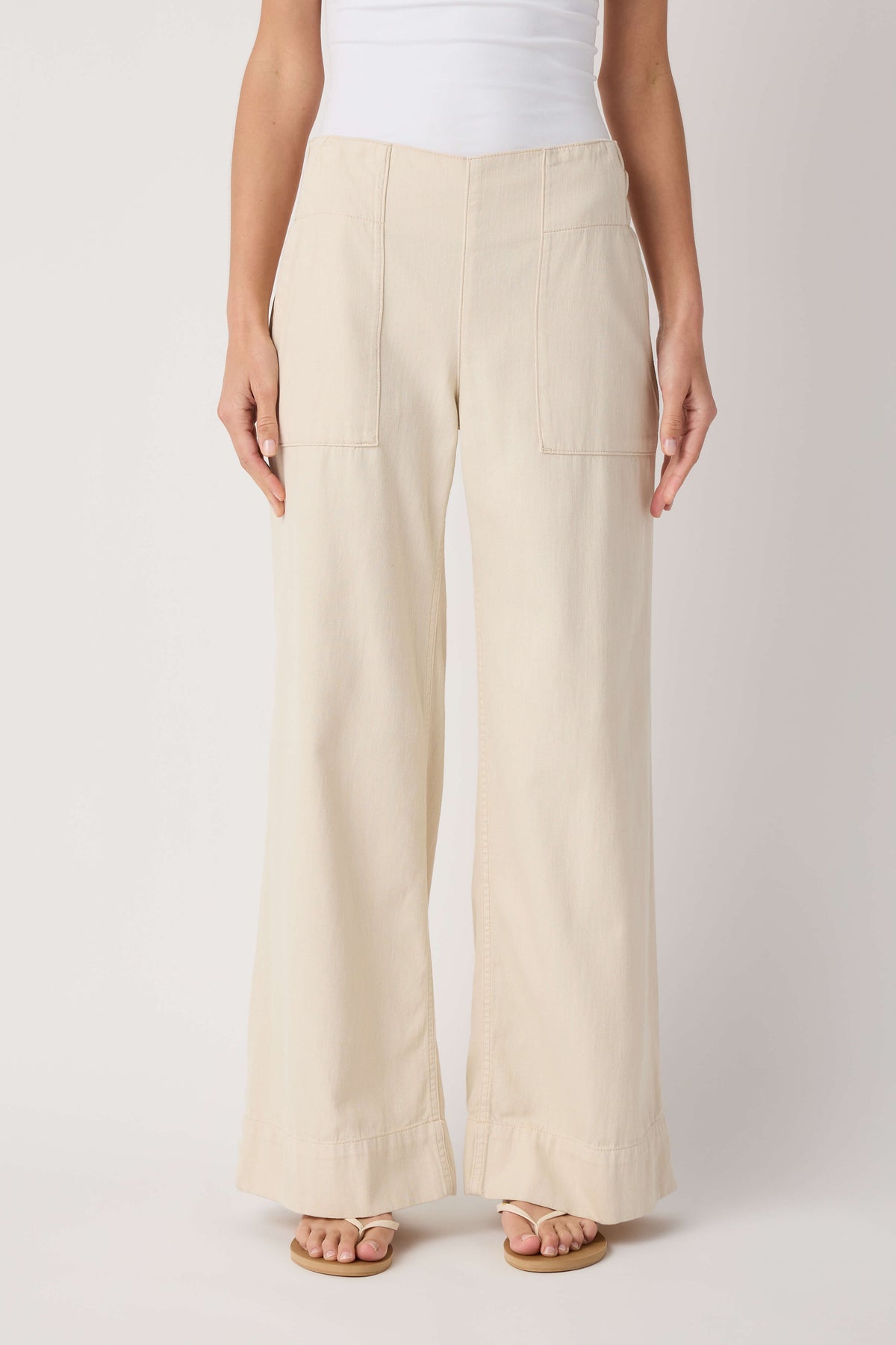Beige denim pull-on pants with front patch pockets and wide straight legs