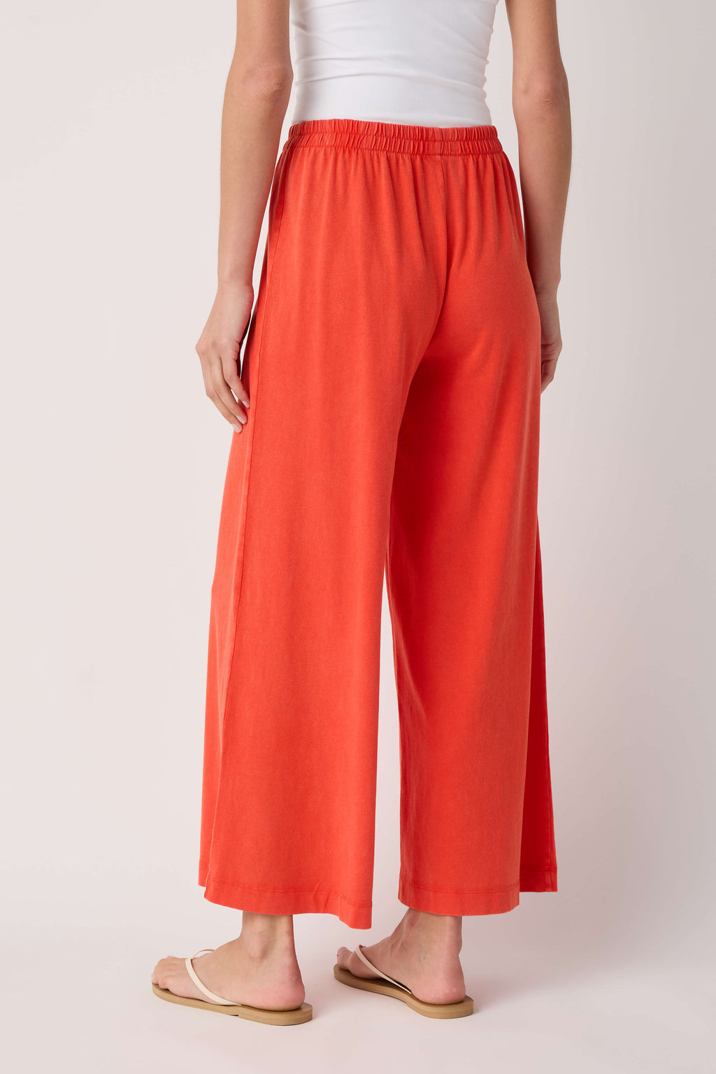 Jersey crop flare pants in coral orange, elastic waistband, wide wide-leg fit.