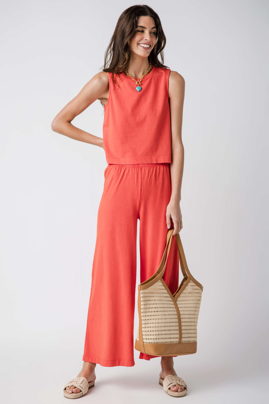 Jersey crop flare pants in coral orange, elastic waist, wide-leg silhouette.