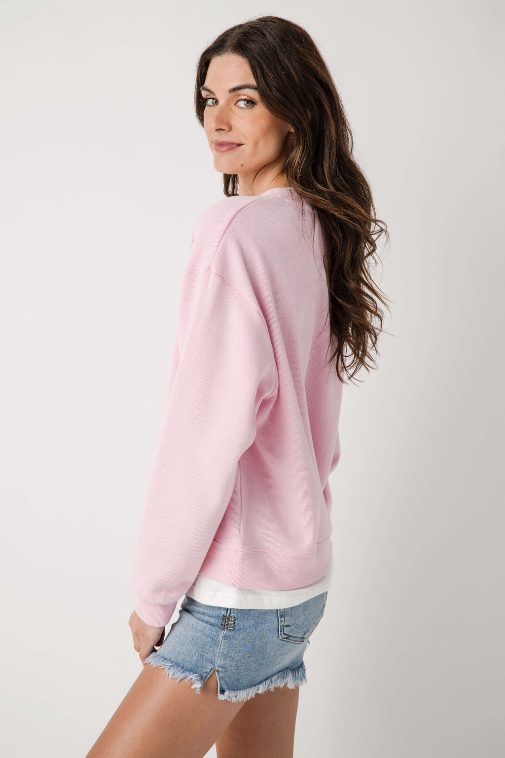 Light pink crew pullover with crew neck, long sleeves, and ribbed cuffs