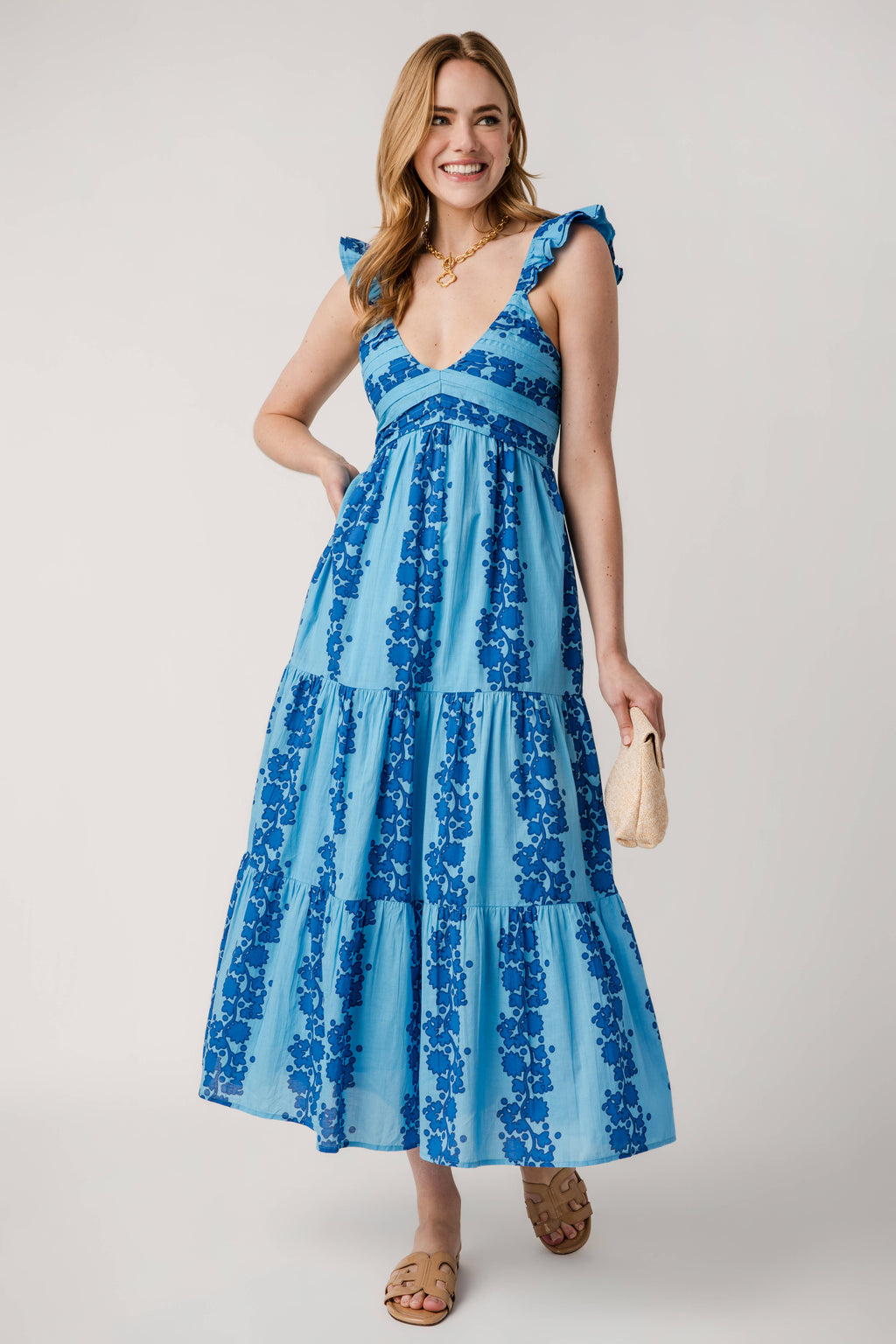 Blue V-neck tiered maxi dress with ruffled shoulder straps and blue floral pattern