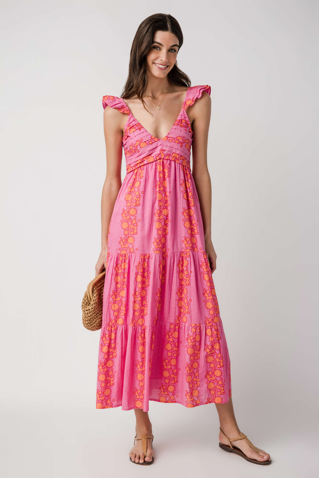 Pink V-neck tiered maxi dress with ruffled shoulder straps and golden floral print