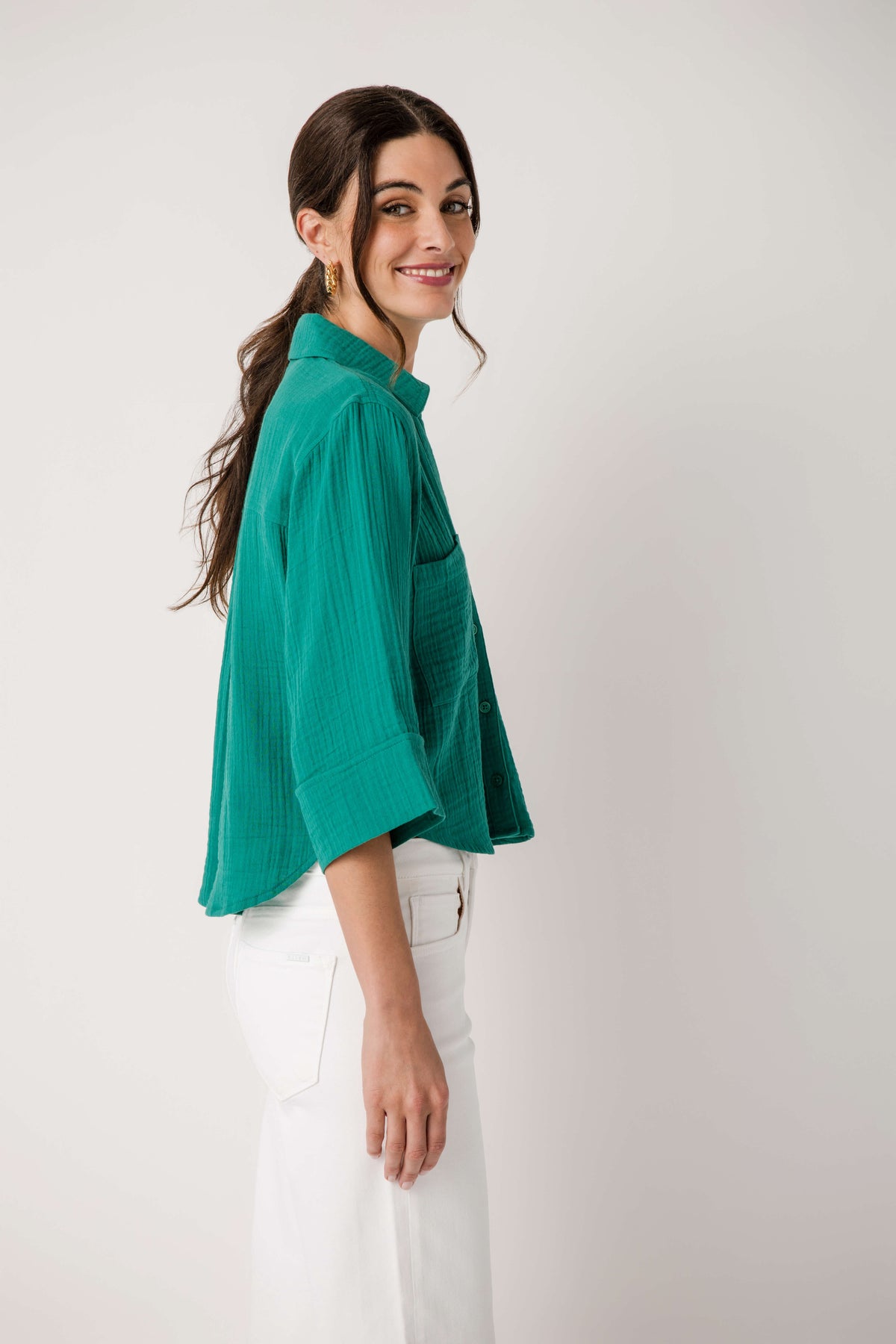 Rainforest green button-front shirt in side profile with chest pocket details