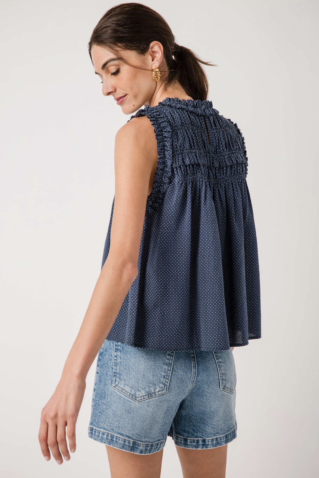 Navy sleeveless smocked birdseye top, back view with gathered yoke