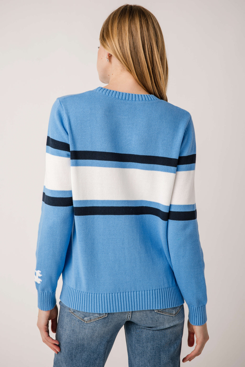 Vintage campus sweater in light blue with dark and white stripe bands on the back