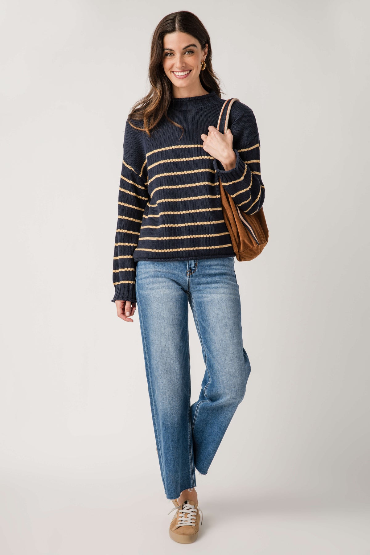 Navy knit mockneck sweater with gold and cream horizontal stripe pattern, ribbed cuffs.