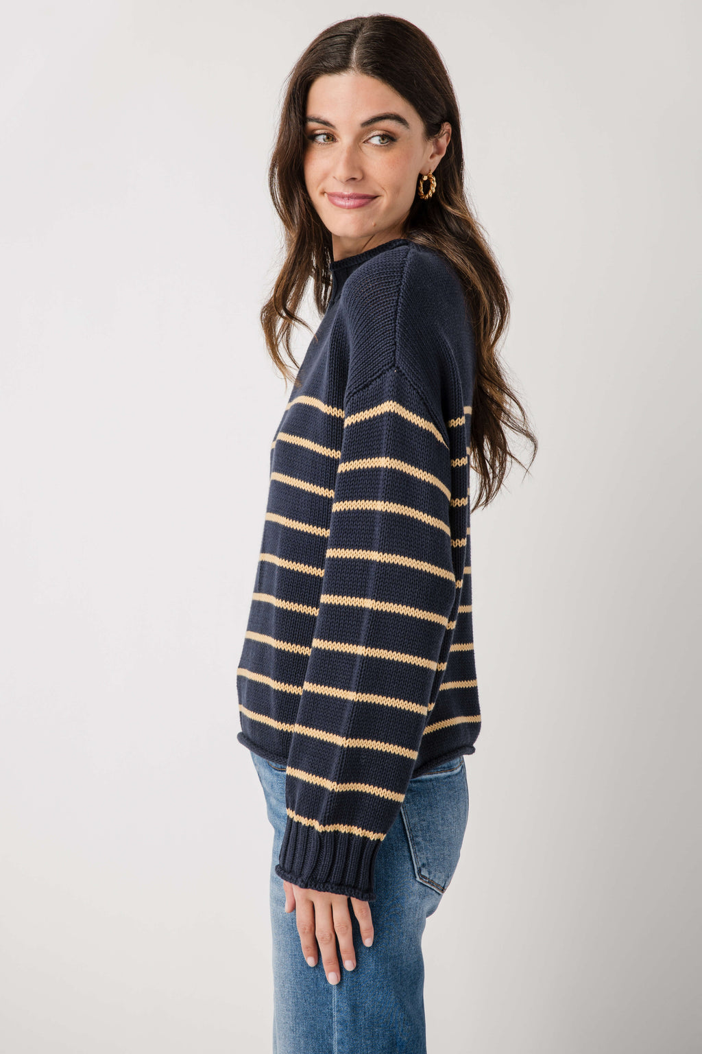 Navy knit mockneck sweater with gold and cream striped bands, long sleeves and ribbed cuffs.