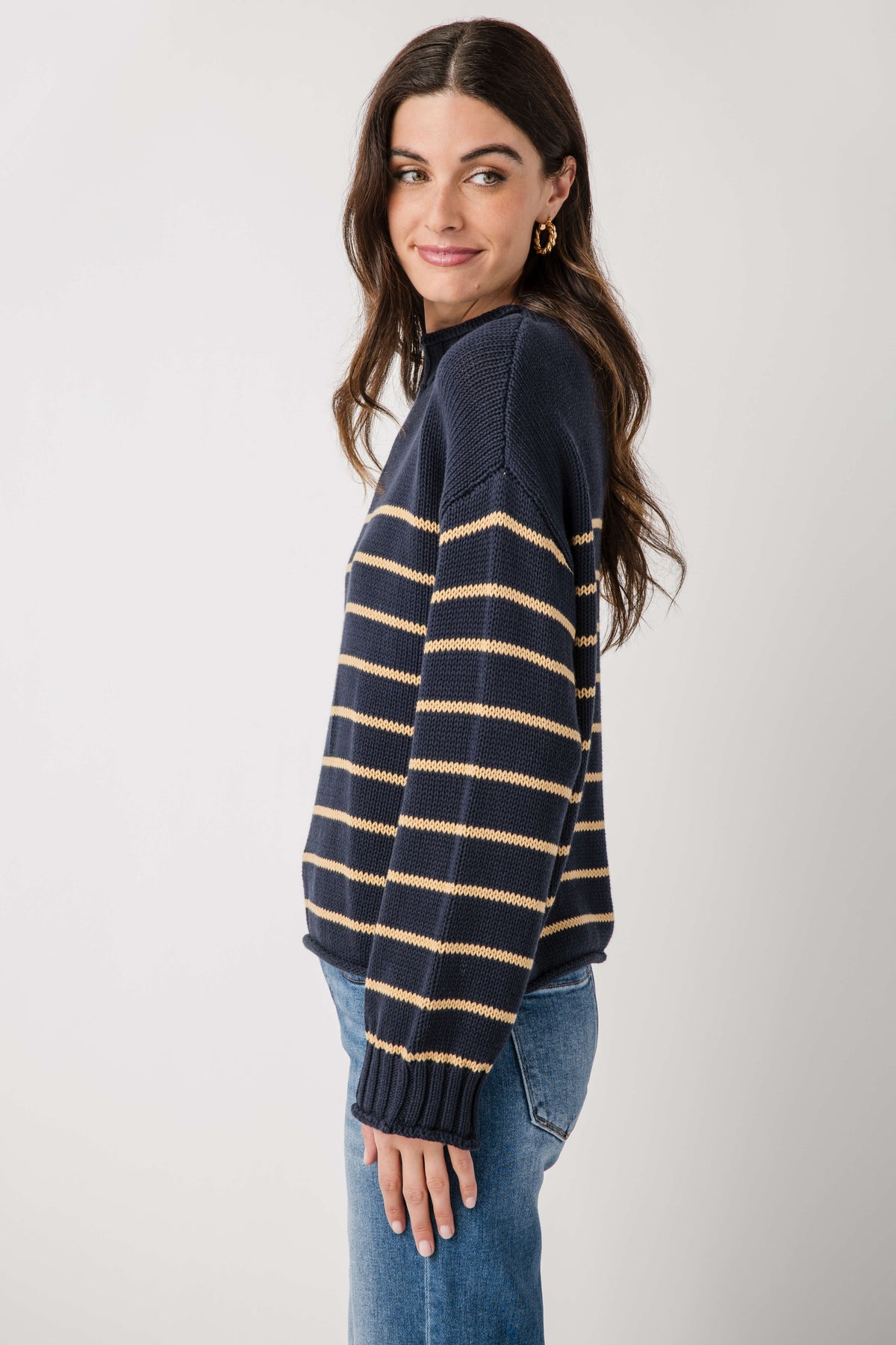 Navy knit mockneck sweater with gold and cream striped bands, long sleeves and ribbed cuffs.