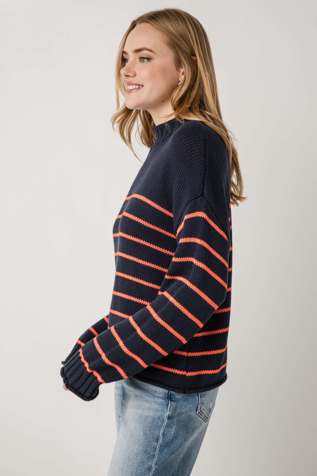 Navy knit mockneck sweater with orange stripe bands, long sleeves and ribbed knit cuffs.