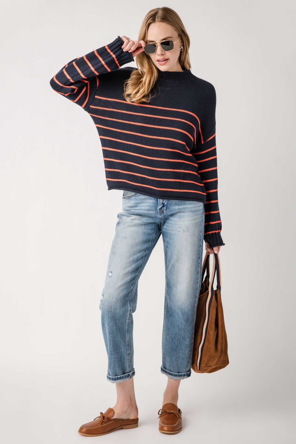 Navy mockneck knit sweater with orange stripe bands and ribbed hem and cuffs.