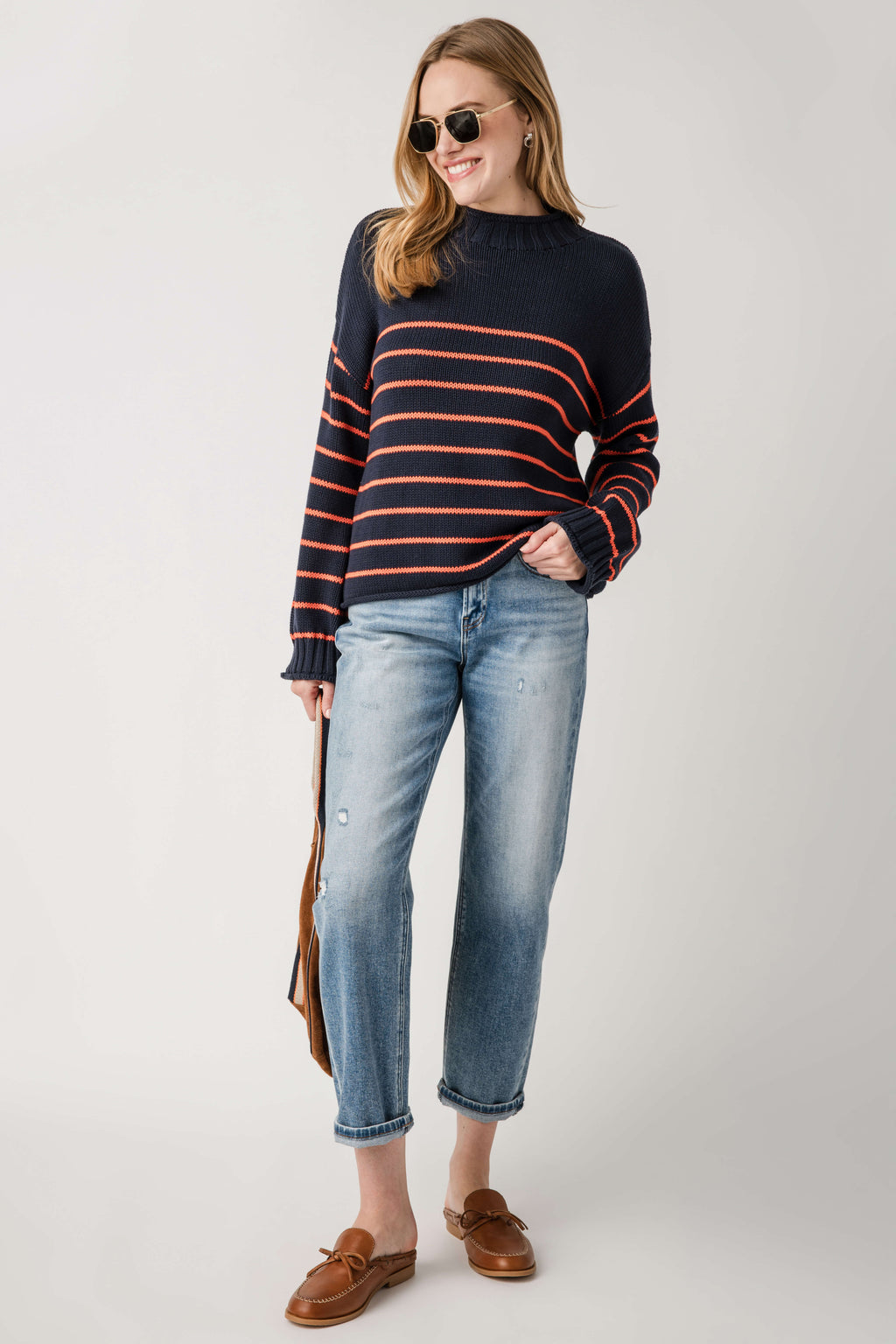 Navy knit mockneck sweater with orange and black horizontal stripes, long sleeves.