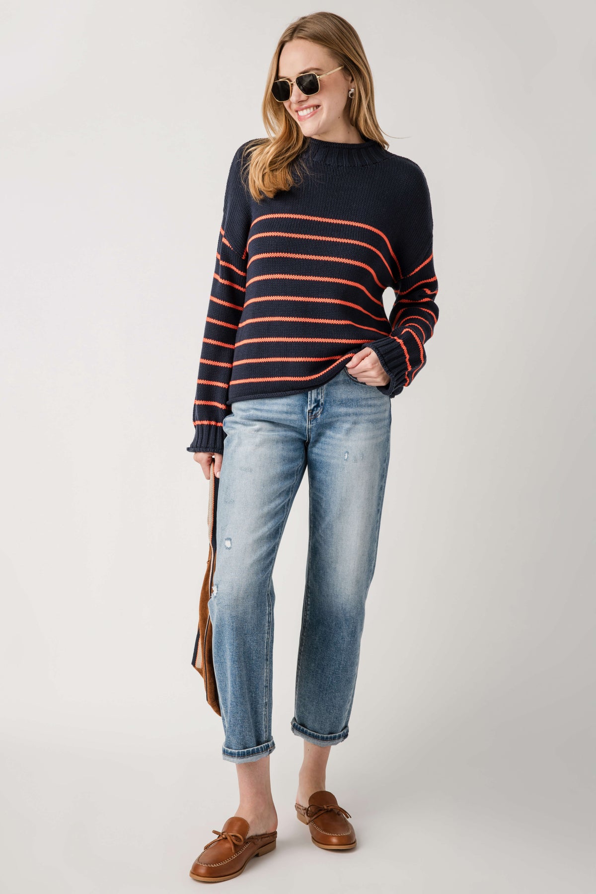 Navy knit mockneck sweater with orange and black horizontal stripes, long sleeves.